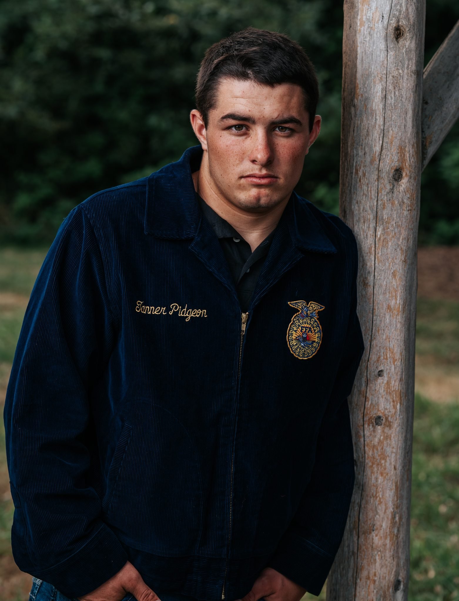 Humboldt County senior portrait of an FFA student leaning against a wooden post photographed by Tex Kelly Productions