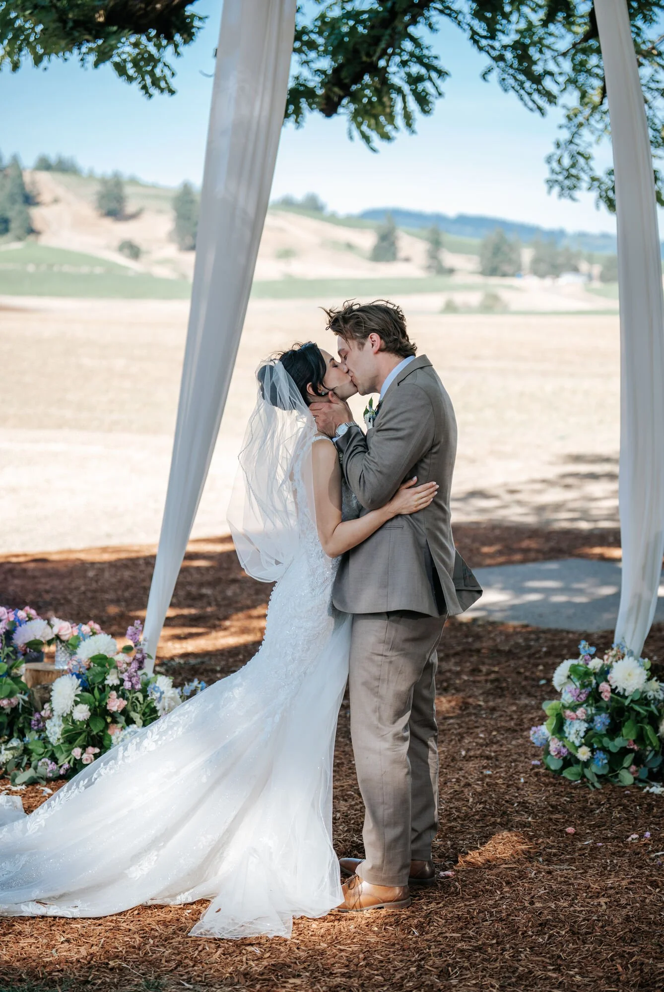 Romantic couple portrait at sunset in Humboldt County. Bride and groom share a kiss with scenic Northern California views. Destination wedding photography by Tex Kelly.