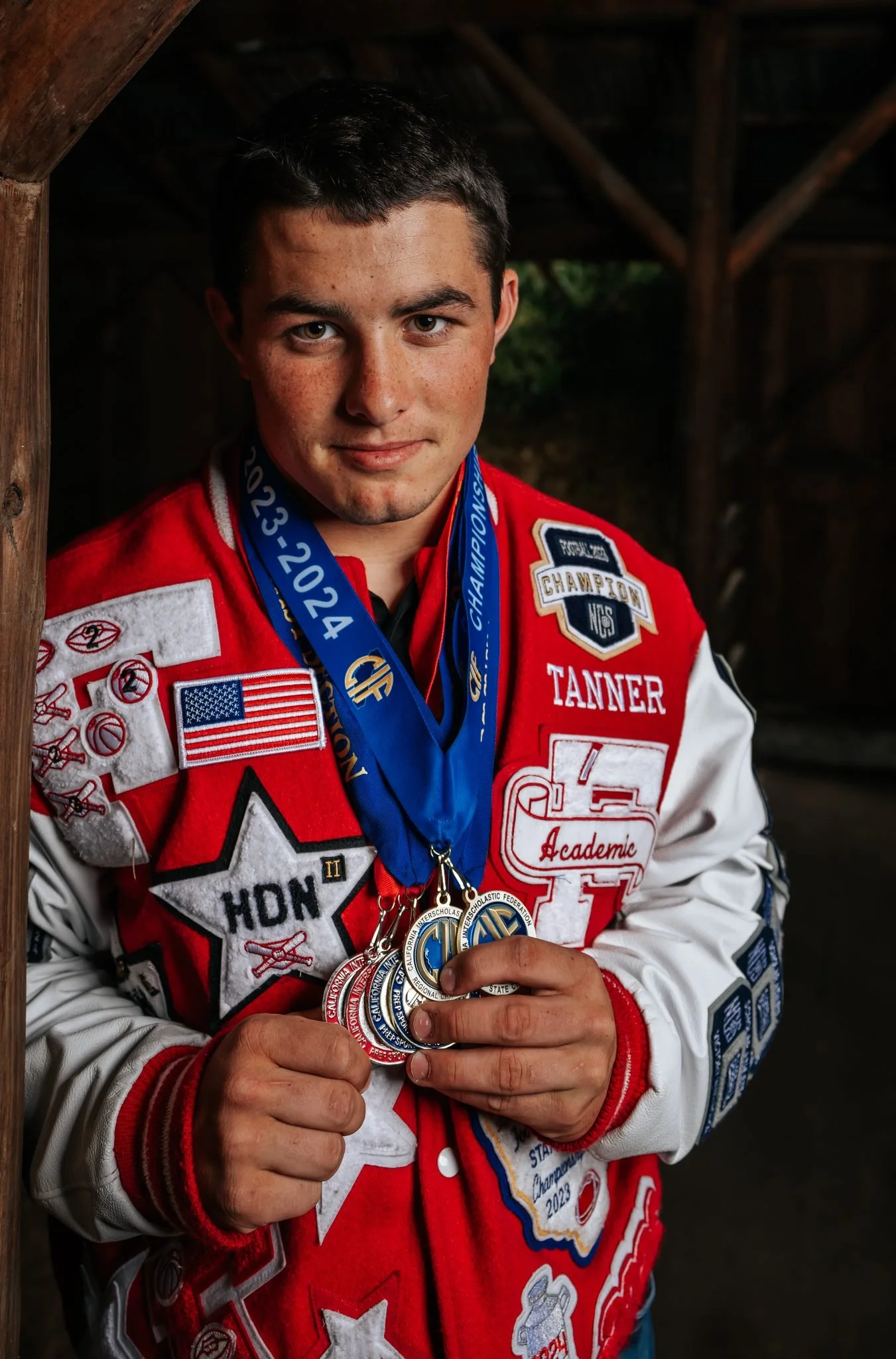 Tanner Pidgeon showing off his hard earned medals during Ferndale High School senior portraits by Tex Kelly Productions