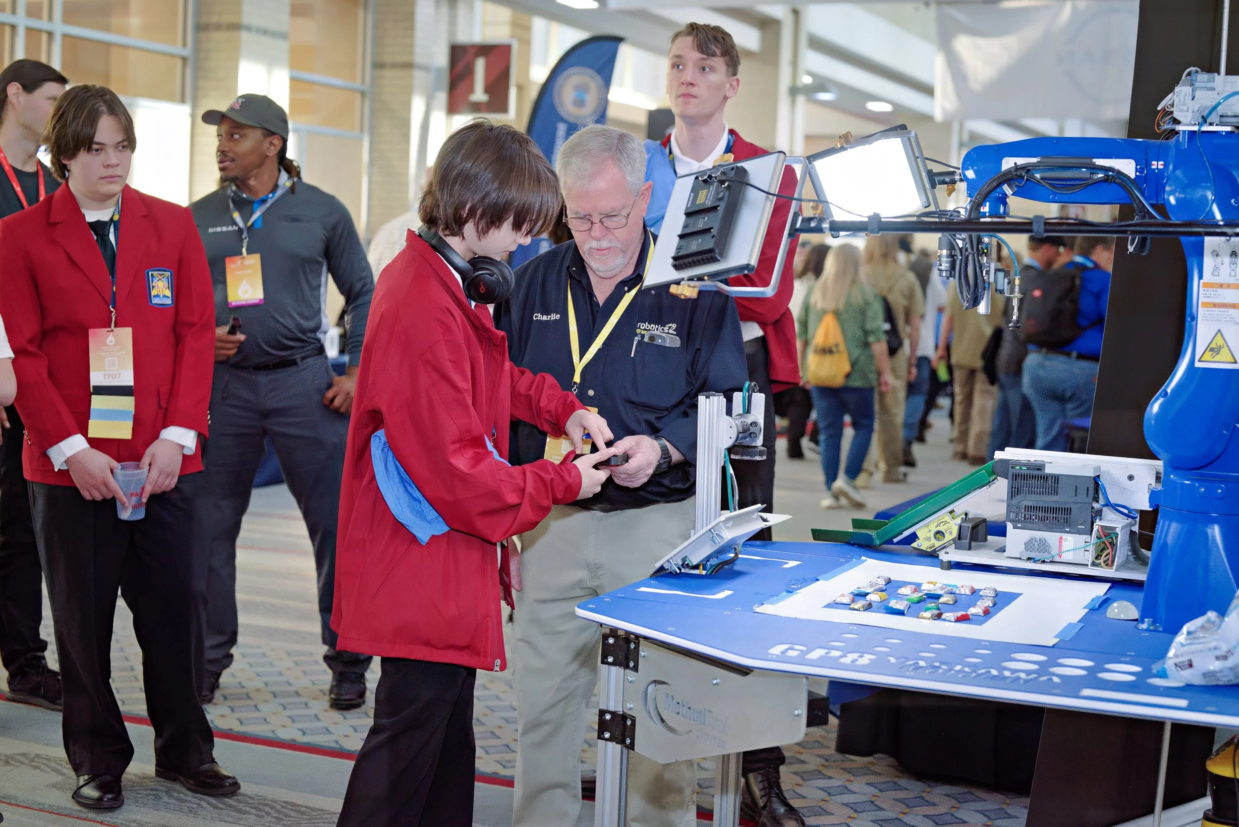 A SkillsUSA member practices using robotics equipment with a SkillsUSA Partner.