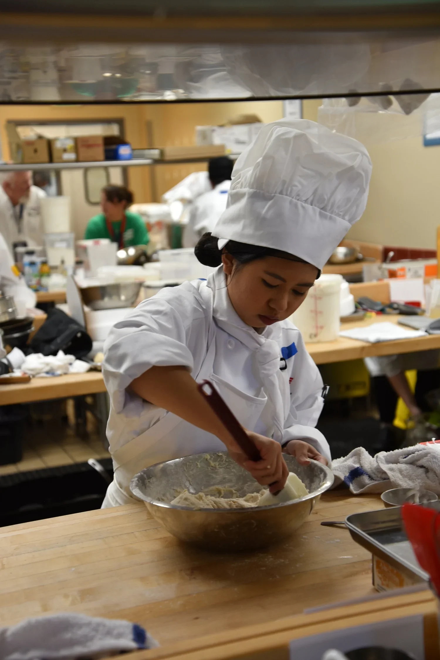 A competitor mixes a bowl of dough during her Baking and Pastry competition.