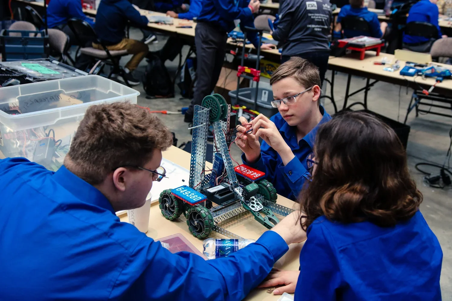 A team of TSA competitors work on improving and repair a robot for competition.