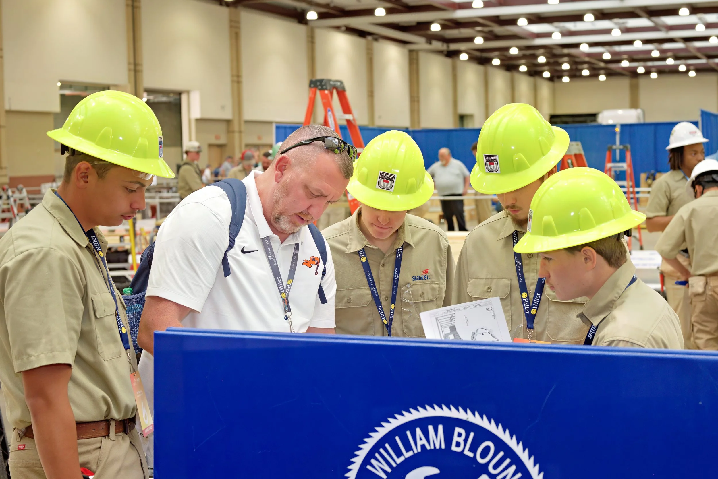 A SkillsUSA advisor reviews competition information in a huddle with his competitors.