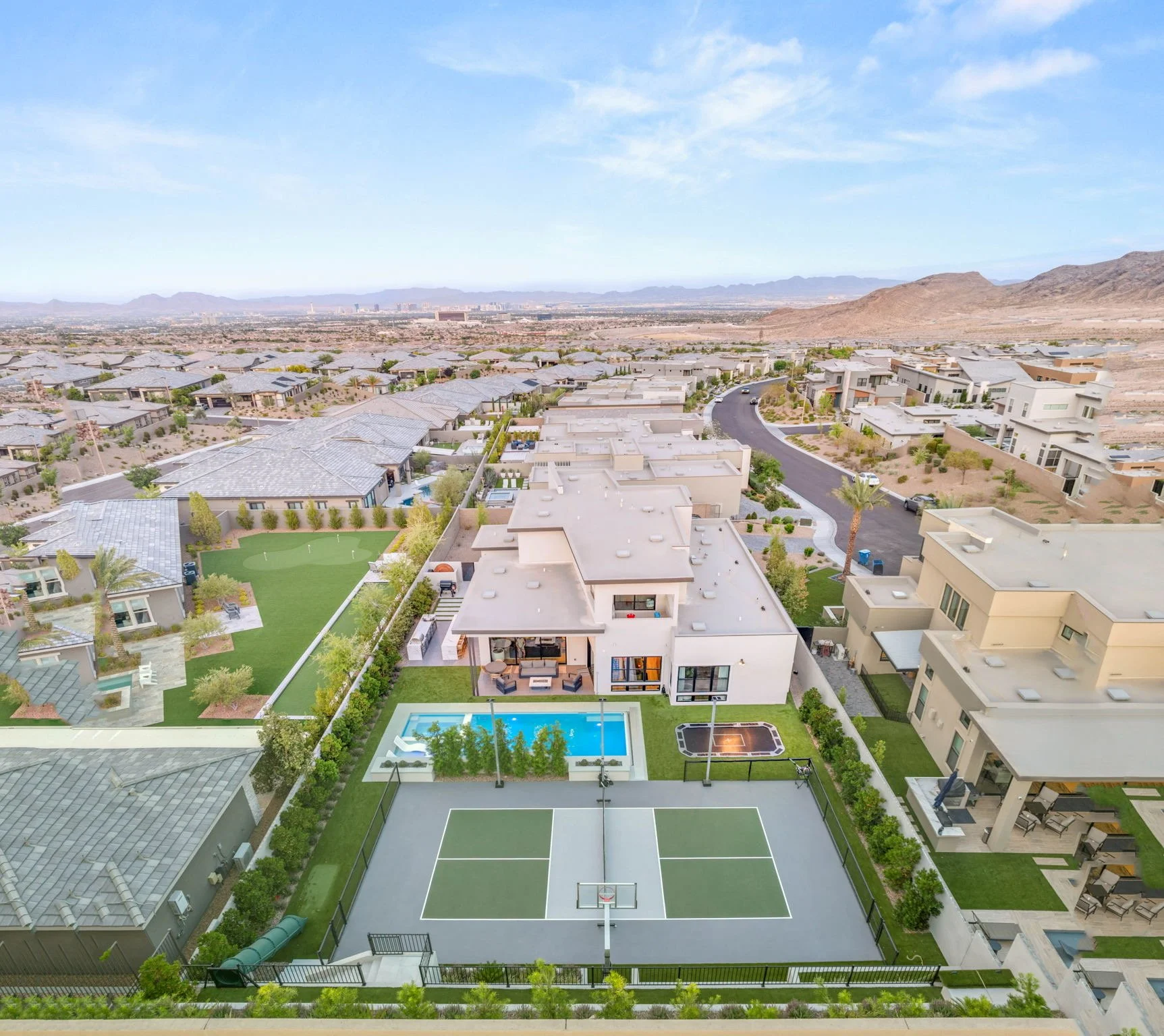 Aerial view of a luxury modern estate landscape design with custom swimming pool, private pickleball court, and mountain views on Lilac Trail Ave, Las Vegas.