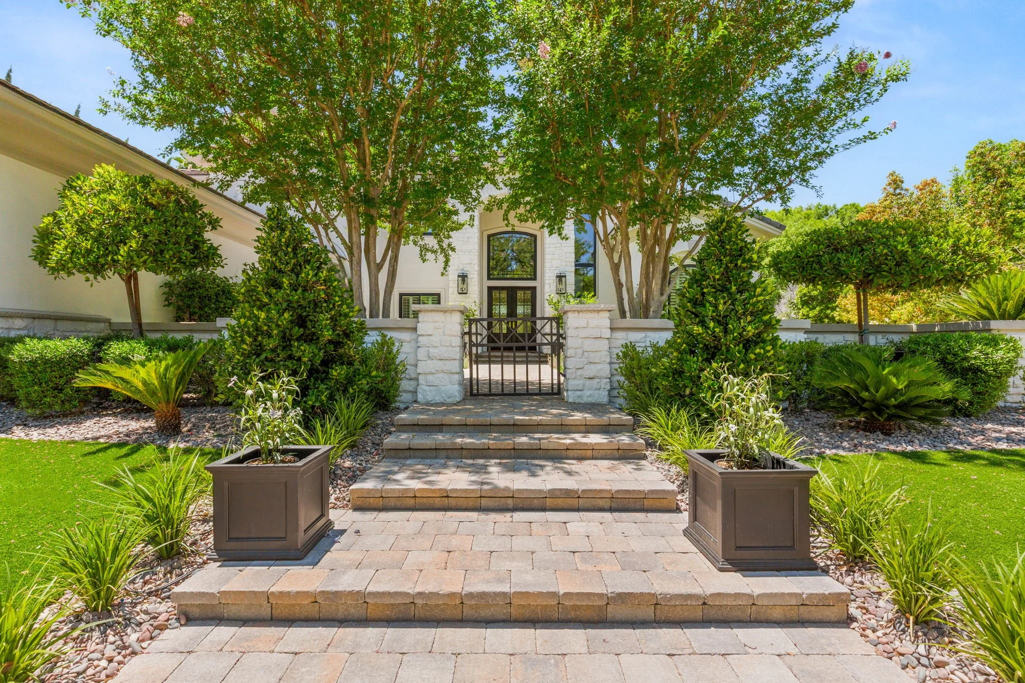 Custom front yard stone paver steps, planter boxes, and wrought iron gate entrance design in White Hawk Ct, Las Vegas NV.