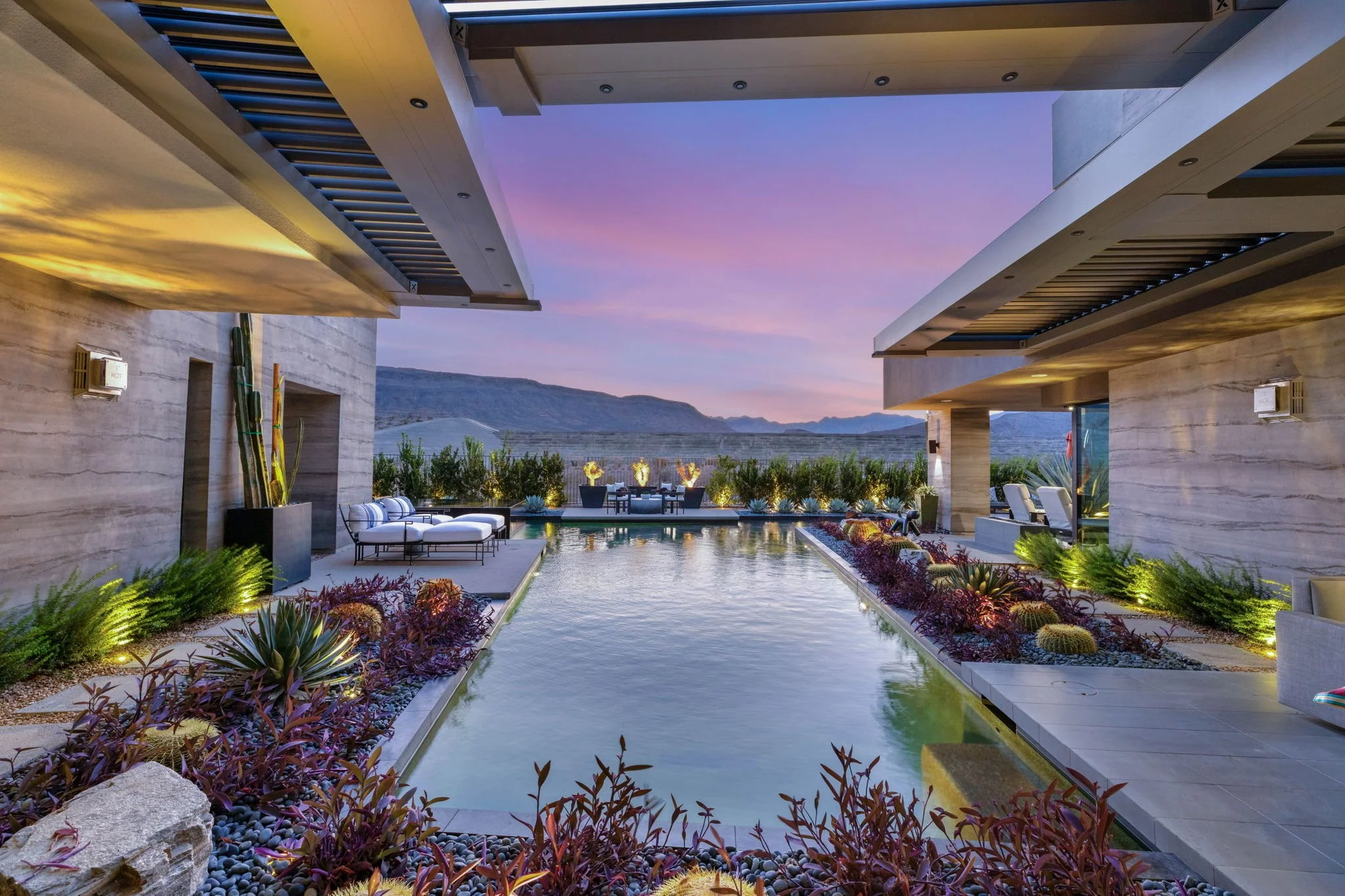 Custom luxury swimming pool installation featuring large-format stone pavers, outdoor lounge terrace, and sunset mountain views in Las Vegas.