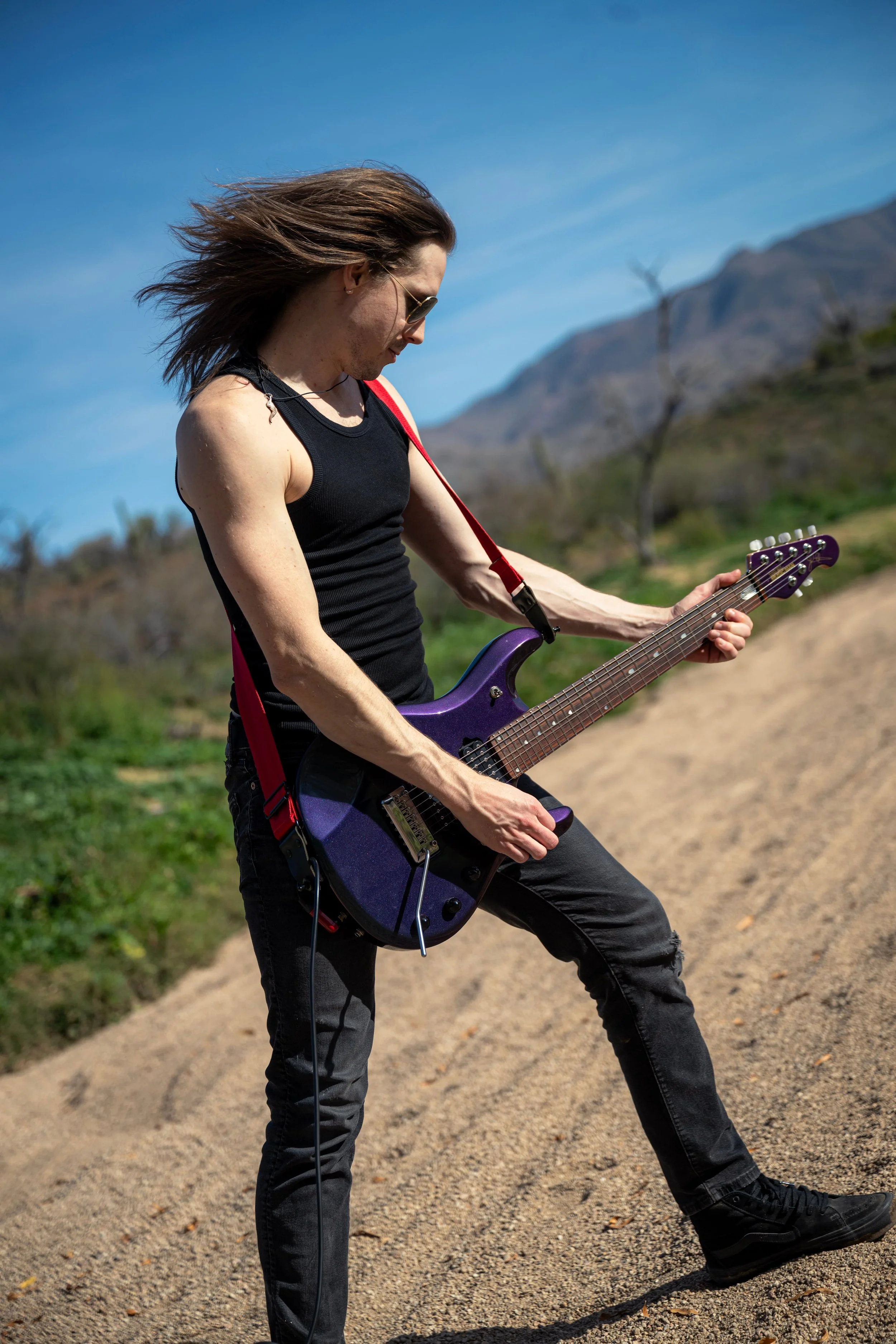 Matt Wright playing guitar in a desert