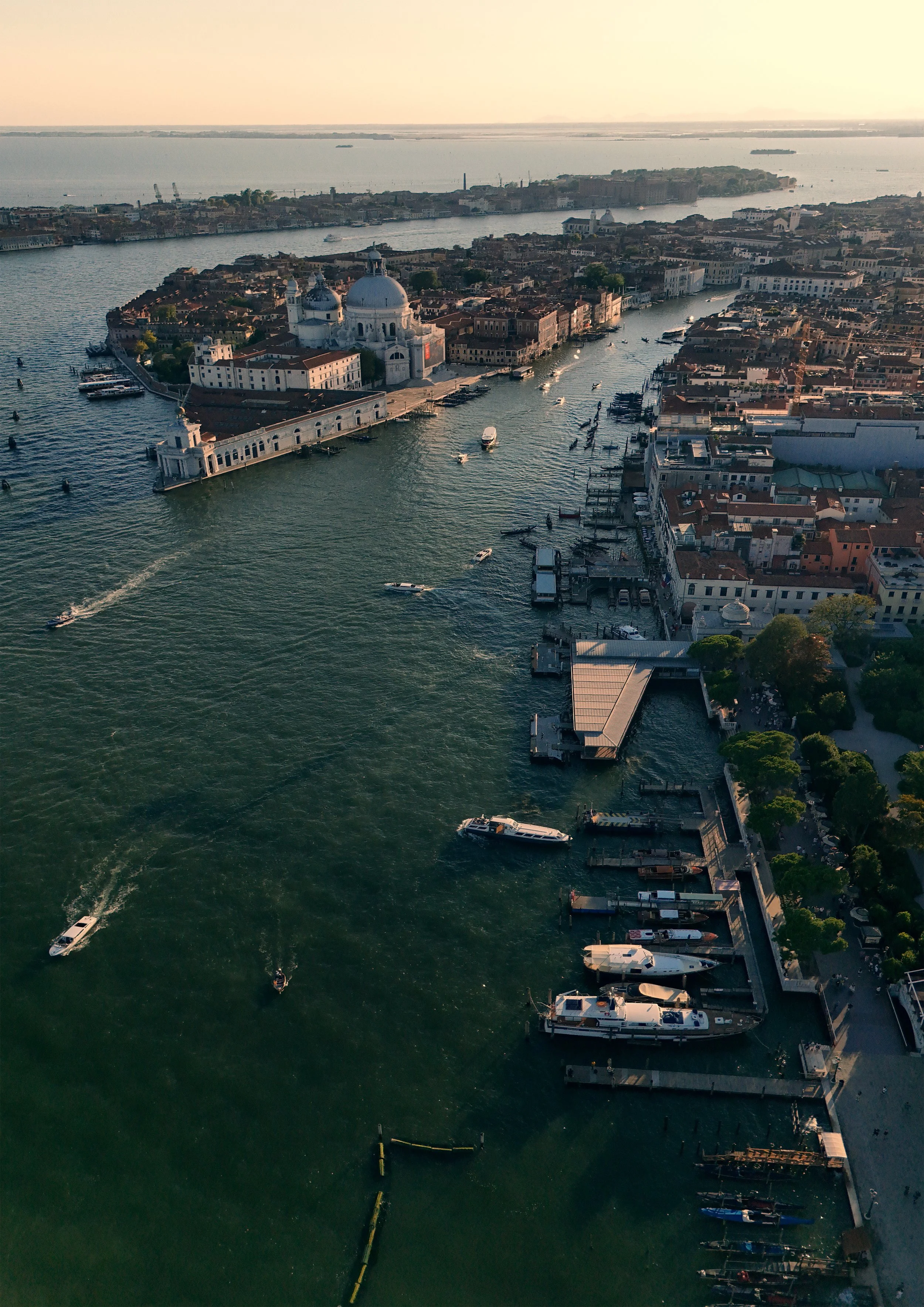 Aerial view of Venice, Italy, showing the Grand Canal with boats and the Santa Maria della Salute basilica in the background.