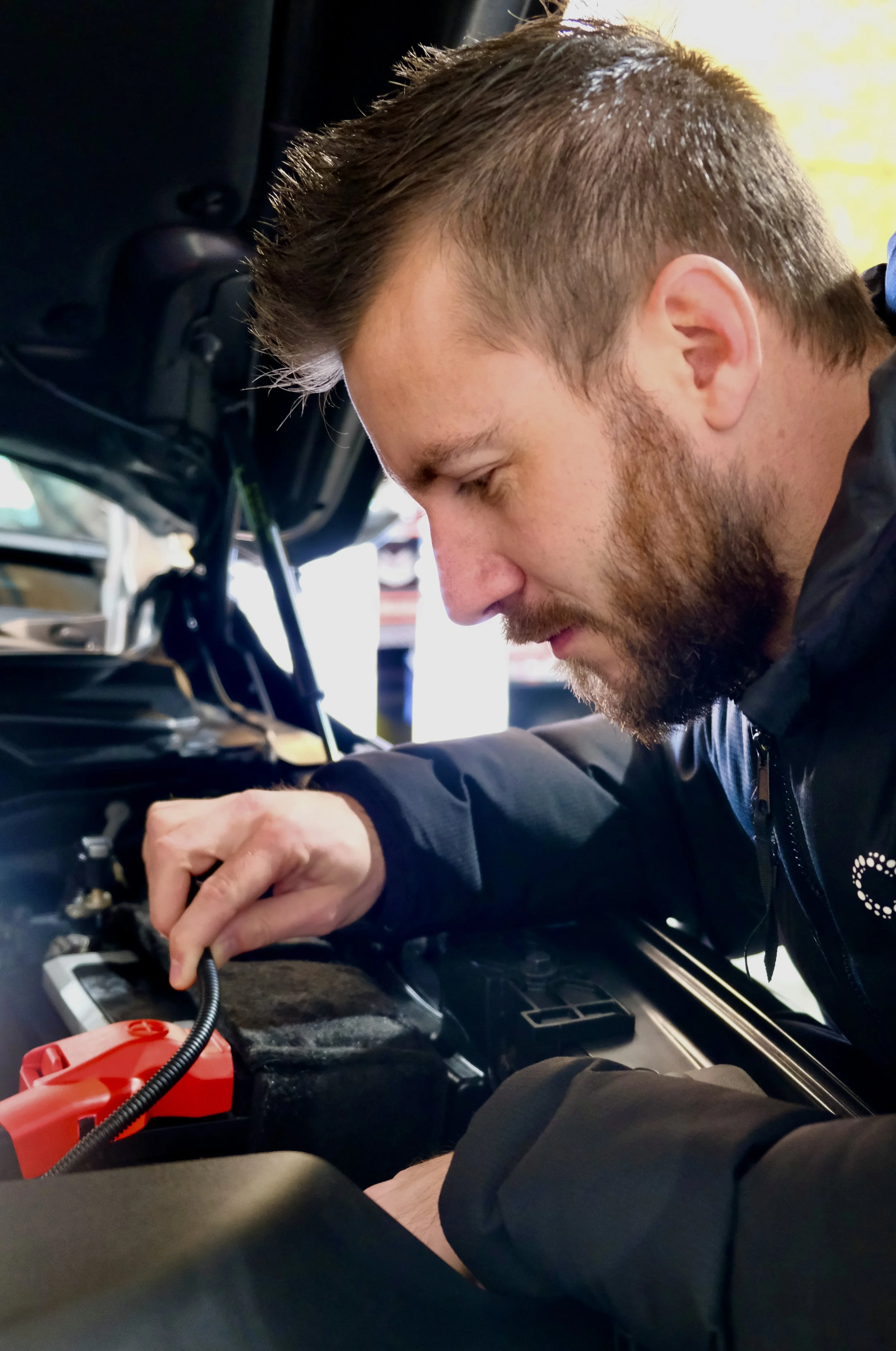 Auto Electrician working on vehicle engine