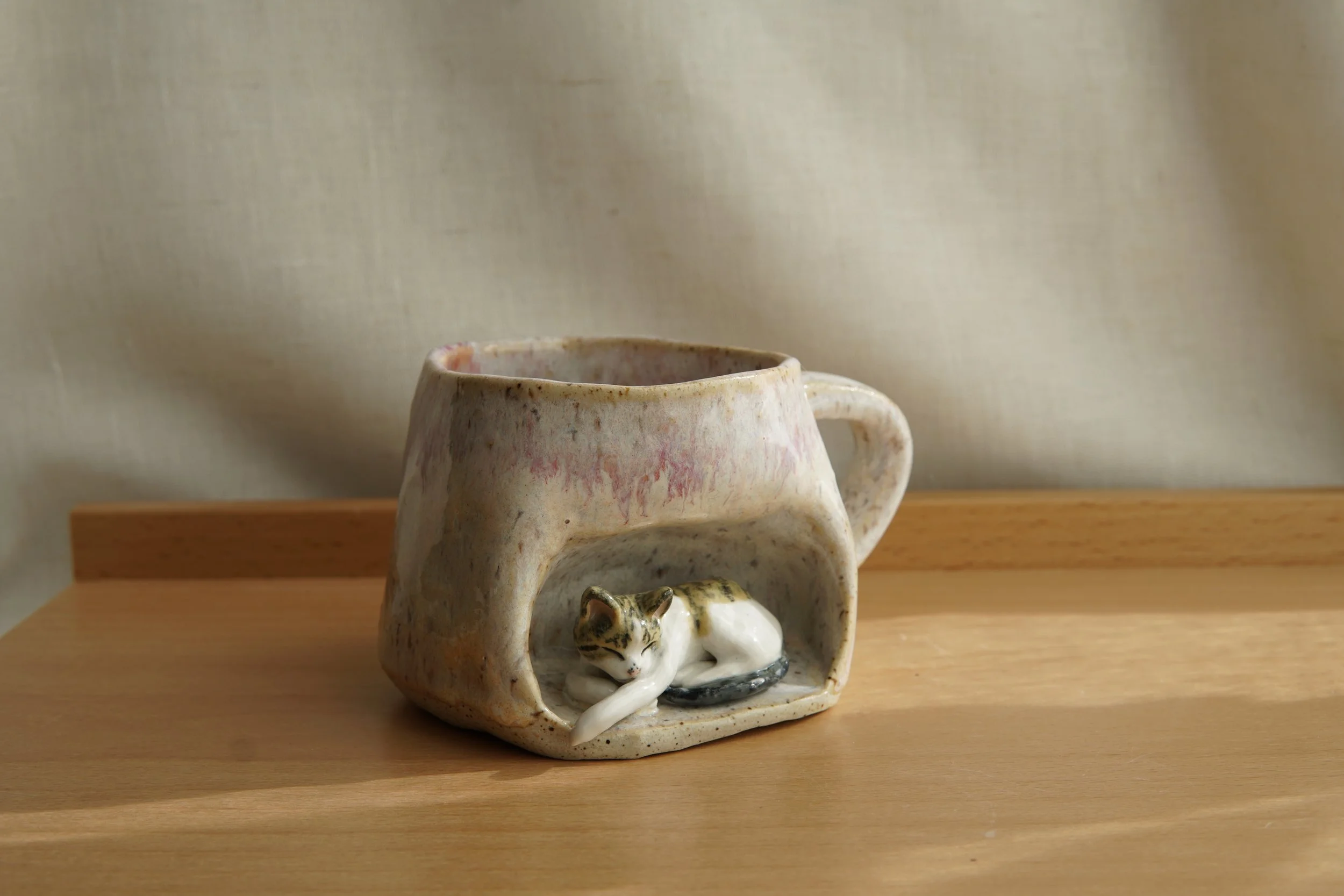 Realistic Cat nested in the mug