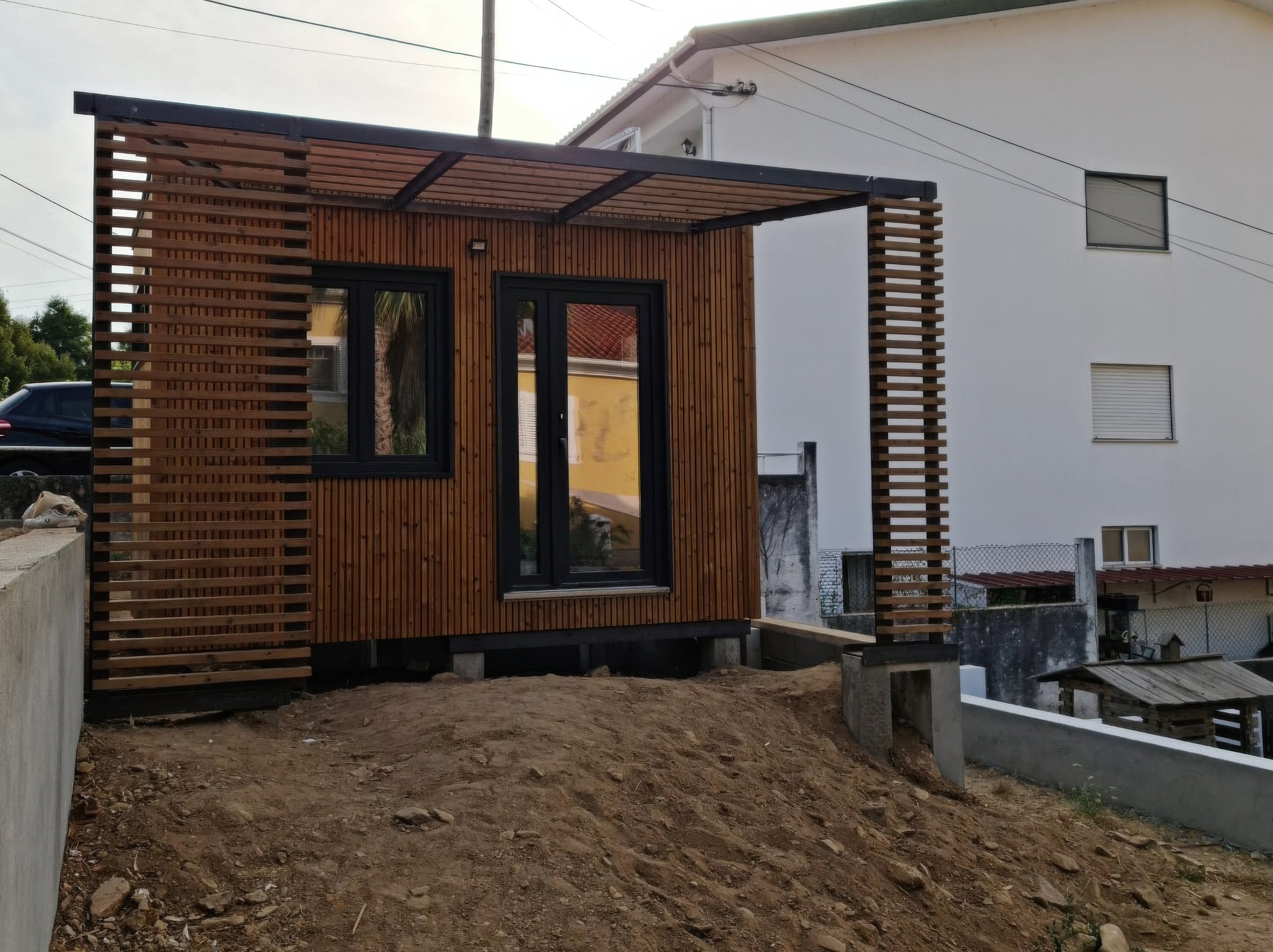 Minimalist interior with large window, staircase, and simple furniture, illuminated by soft natural light.