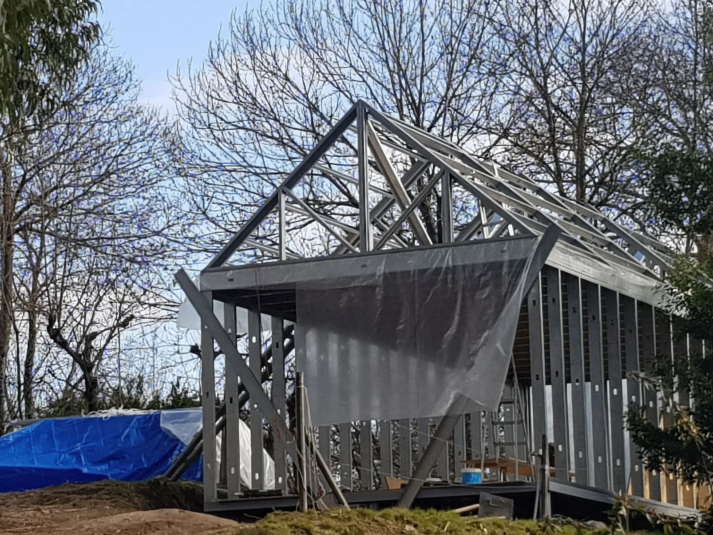 Minimalist interior with large window, staircase, and simple furniture, illuminated by soft natural light.