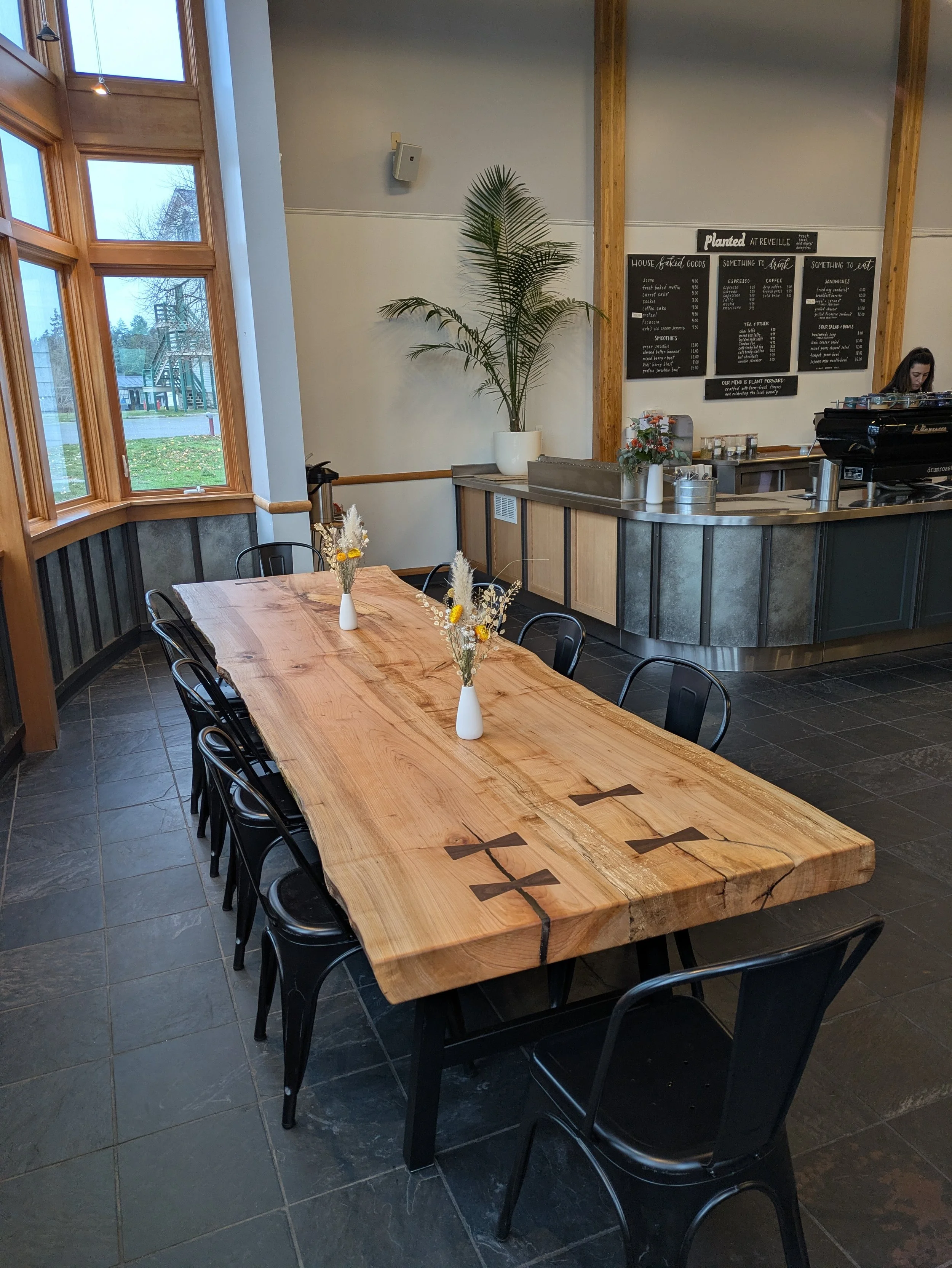 Custom big leaf maple slab dining table showing dovetail key inlays and natural wood grain detail