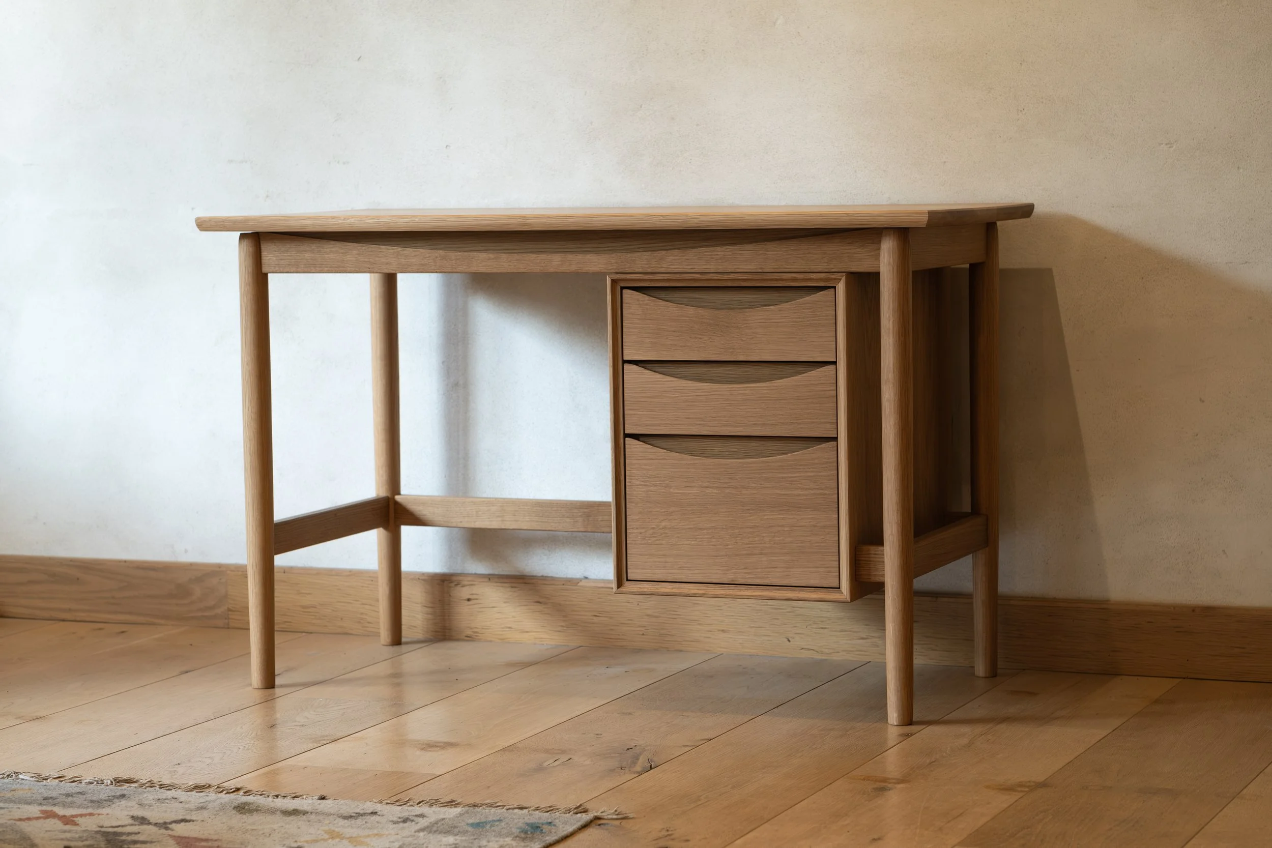 Handcrafted Wren Desk in solid white oak, front angle view showing floating drawer bank