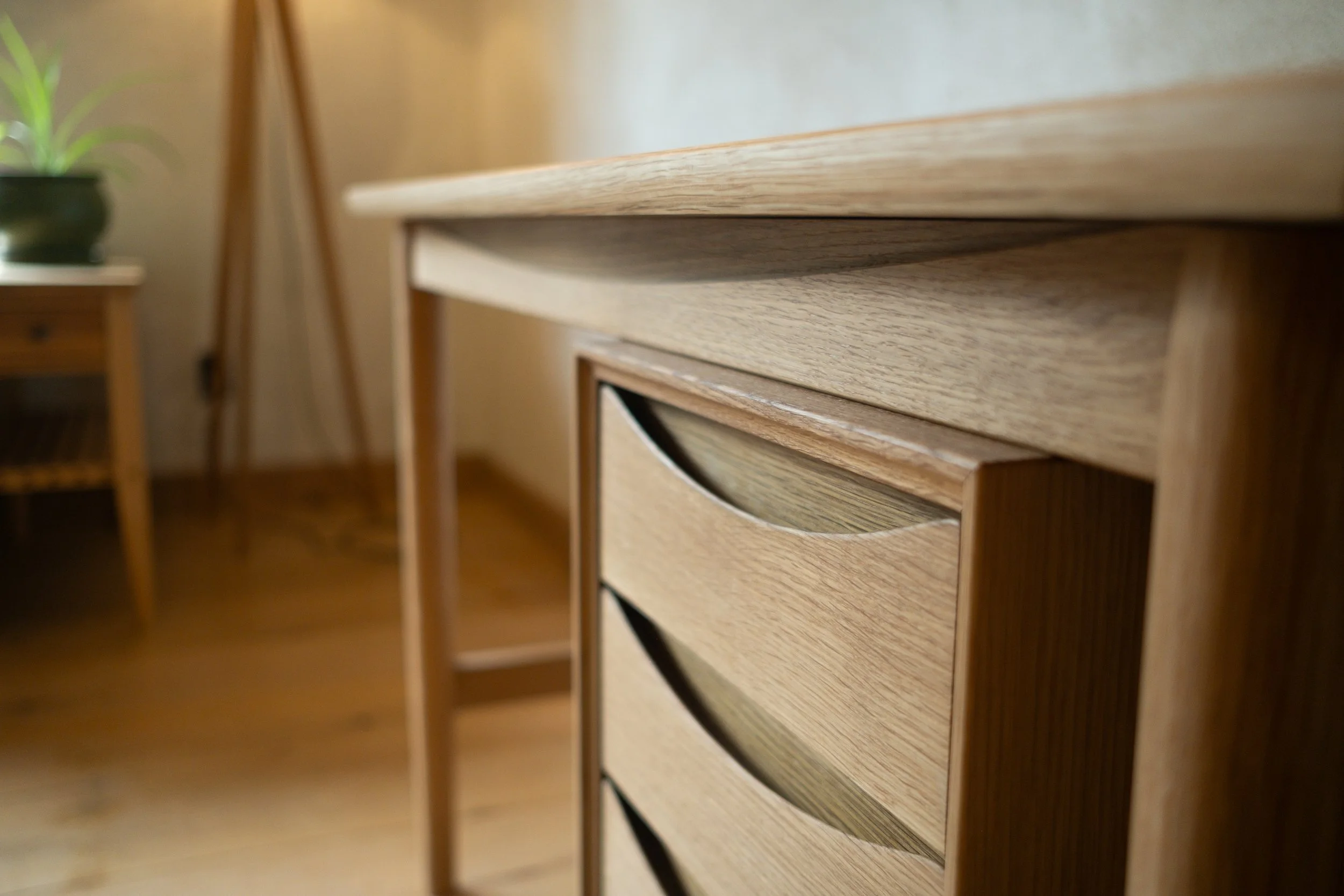 Close-up of Wren Desk drawer bank showing ellipse pulls and desktop edge
