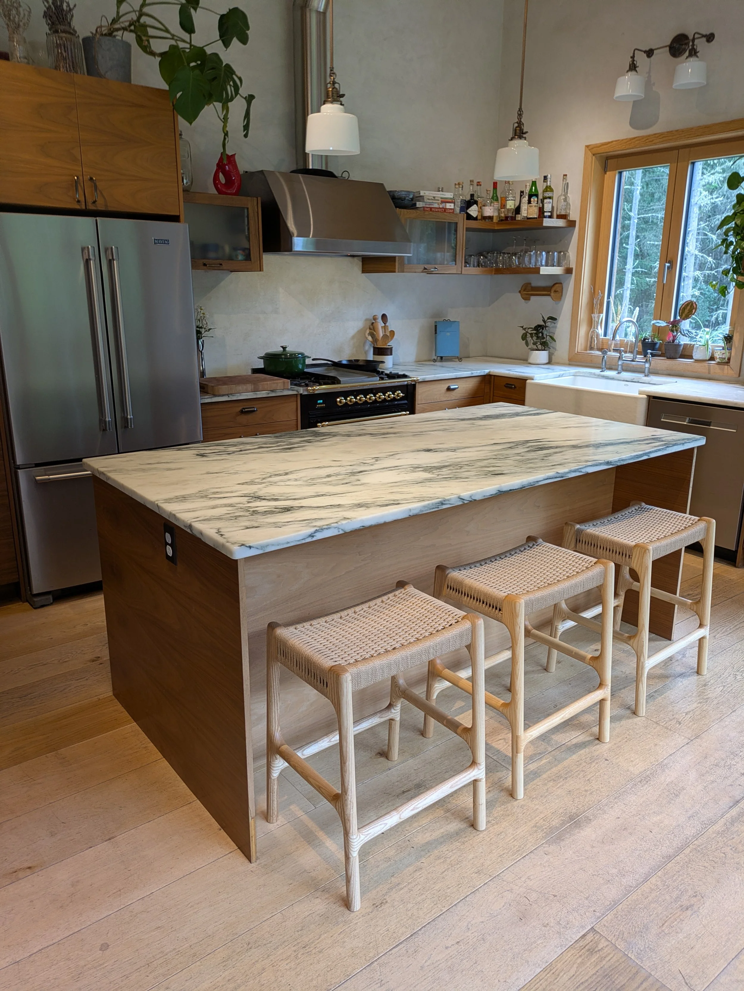 Rast counter stools at kitchen island, full room view with marble countertop and PNW cabinetry