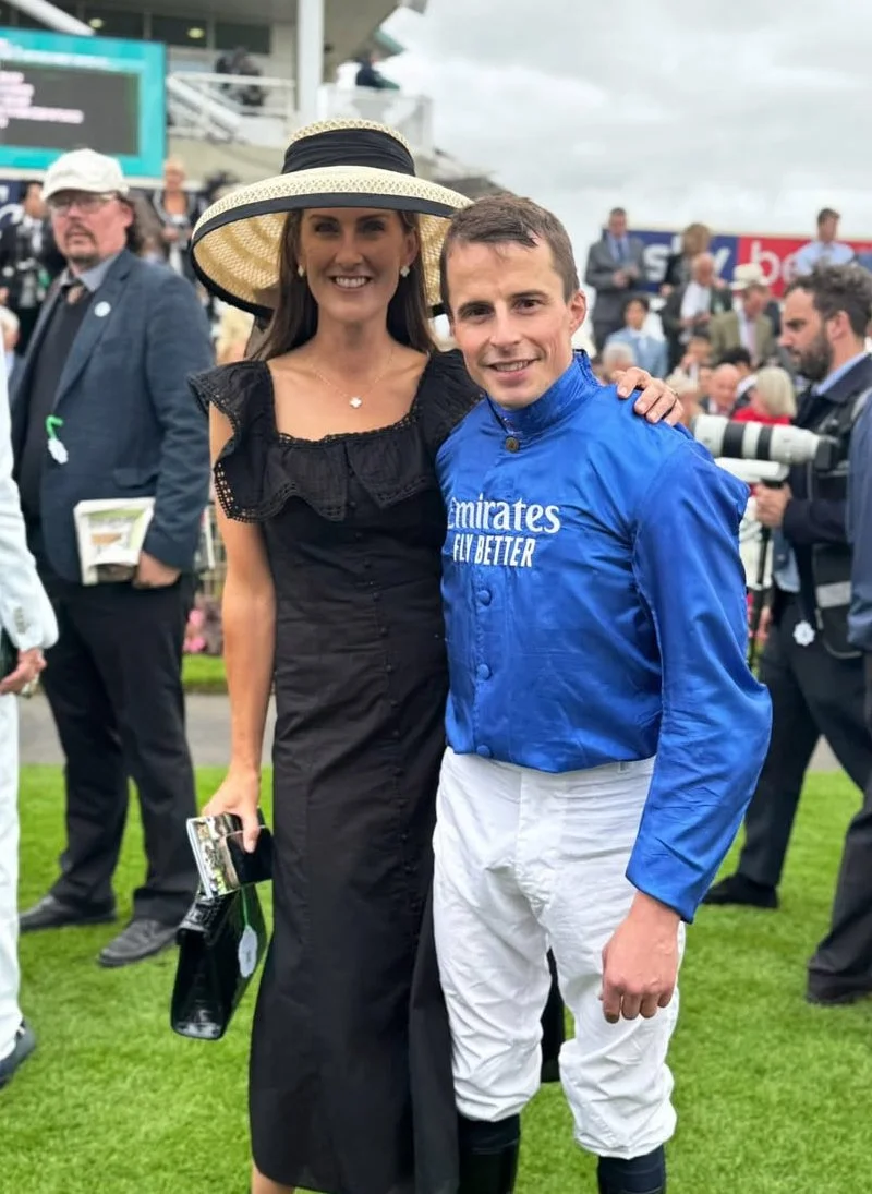 Jane Buick in a large sisal straw 'dior' down brim hat with her winning jockey husband William Buick