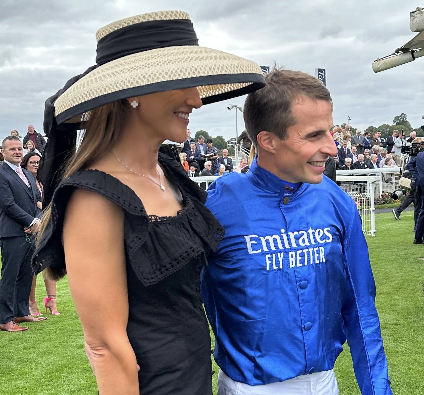 Jane Buick in a large sisal straw 'dior' down brim hat with her winning jockey husband William Buick
