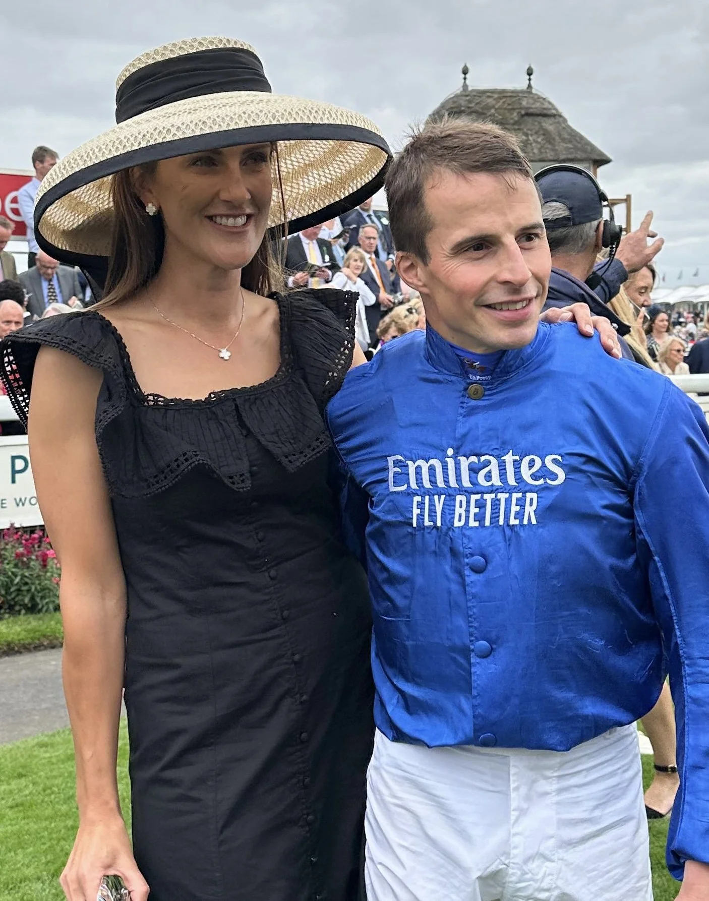 Jane Buick in a large sisal straw 'dior' down brim hat with her winning jockey husband William Buick