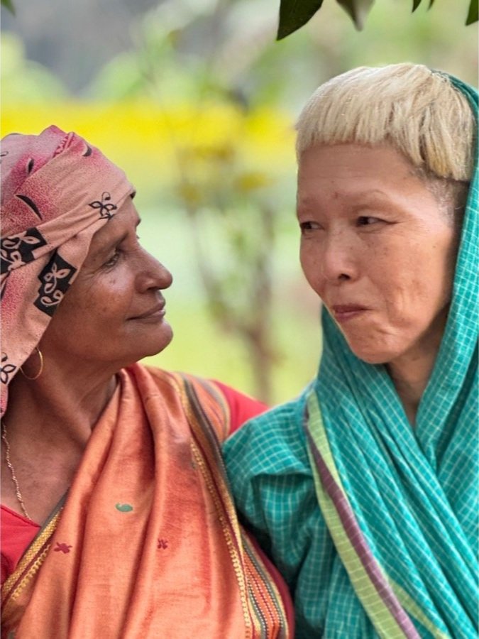 Two women in traditional sarees at The Art Farm, Goa - intergenerational connection and cultural community gathering in India.