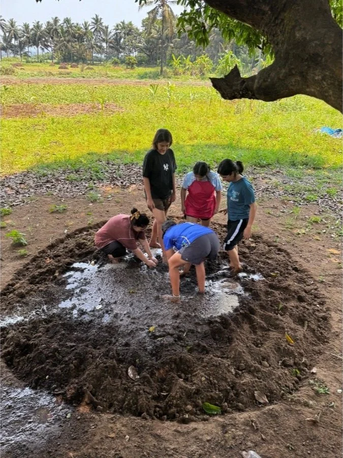 Women participating in a team-building workshop through playful soil activities at The Art Farm, Goa - hands-on group bonding and nature-based learning in India.