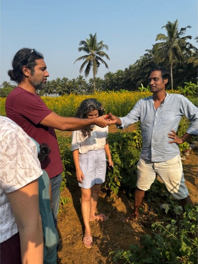 Parents and children enjoying a farm visit to harvest and taste seasonal vegetables at The Art Farm, Goa - sustainable food education and community experience in India.