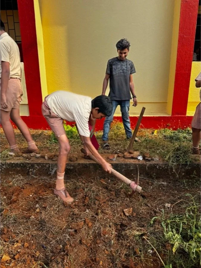 School children learning organic gardening  and learning to use tools with The Art Farm, Goa, as part of a community farming education program in India