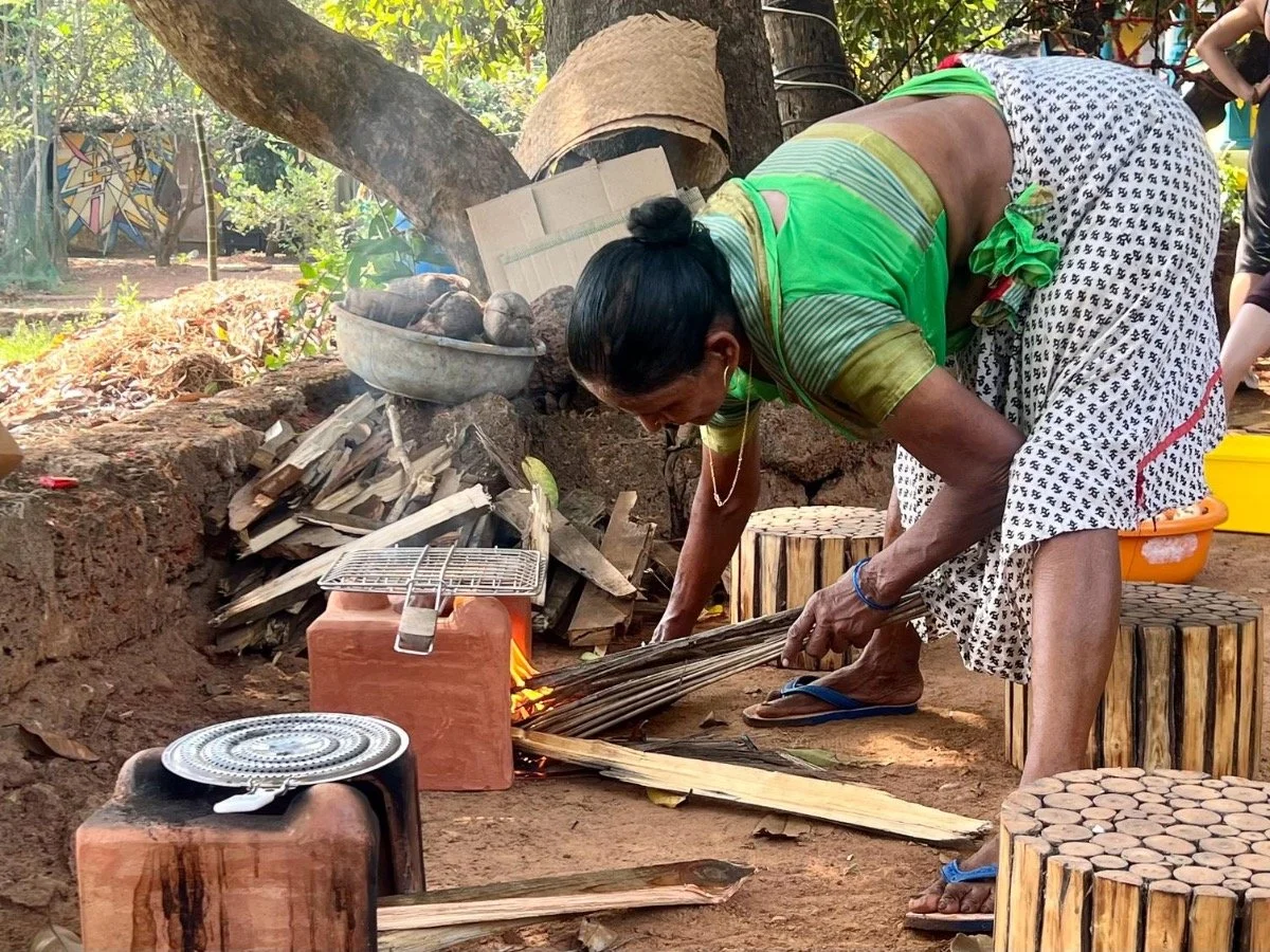 Local woman preparing a traditional wood-fired meal at The Art Farm, Goa - showcasing sustainable cooking practices and rural community life in India