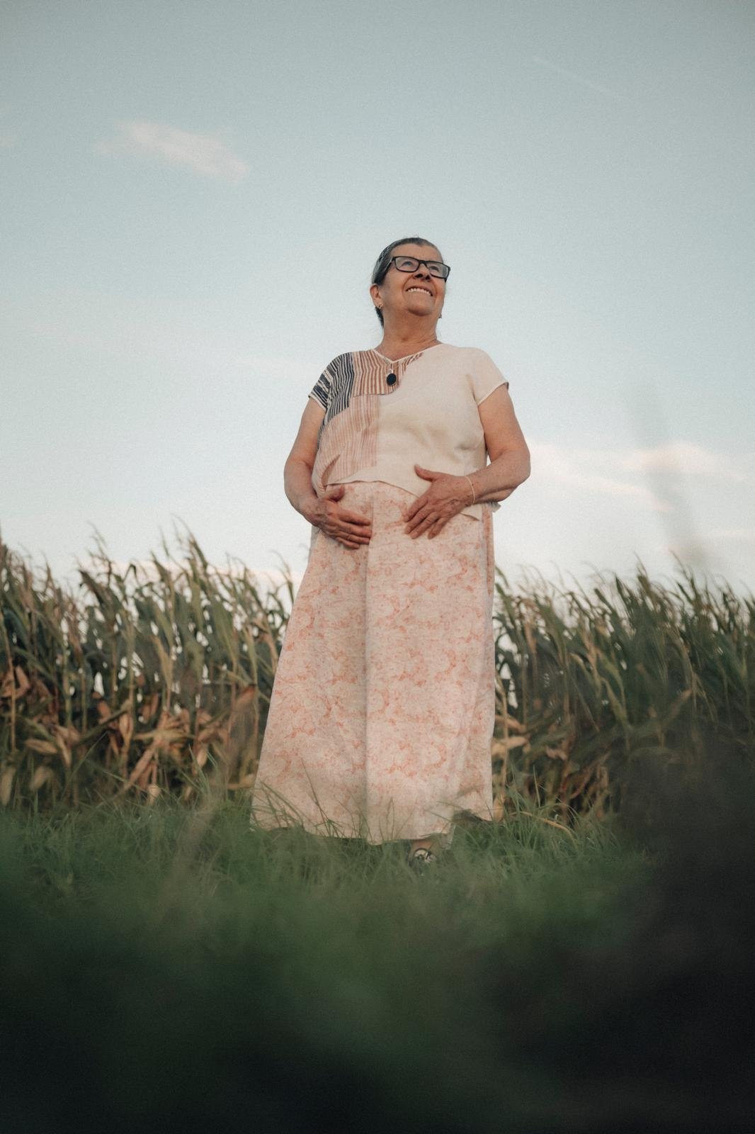 Frau in weißem Kleid vor Maisfeld