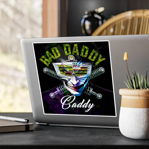 Laptop with a sticker that says 'BAD DADDY' and 'Daddy', featuring a skeleton wearing futuristic sunglasses and surrounded by mechanical elements.