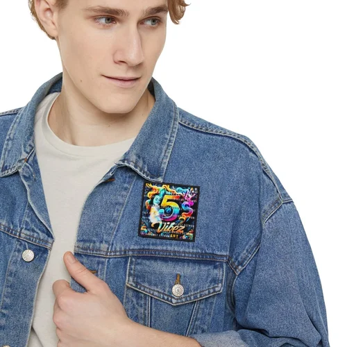 A young man wearing a blue denim jacket with a colorful, graphic '7' patch on the chest.