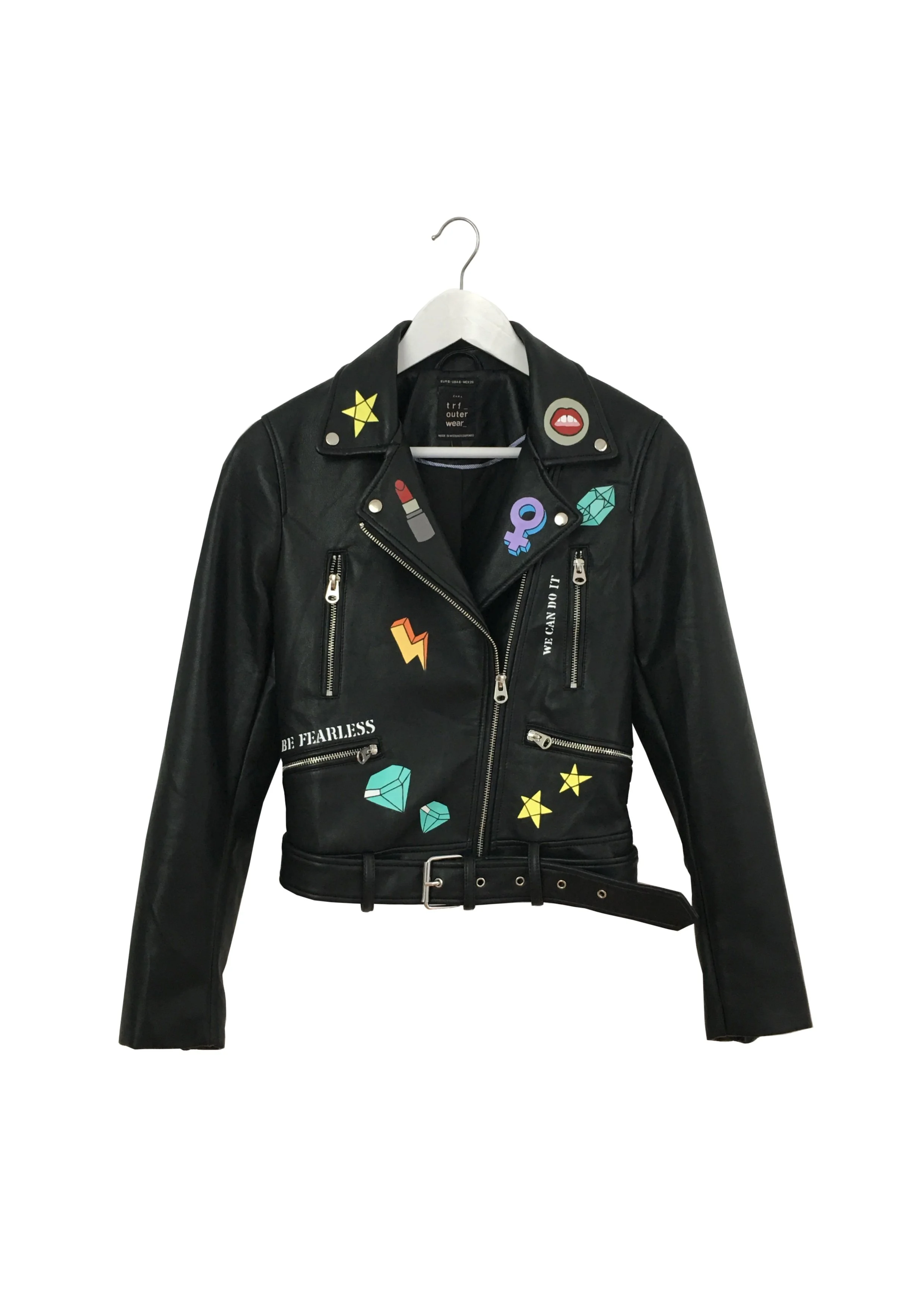 Black leather jacket decorated with colorful patches and pins, displayed on a hanger against a white background.