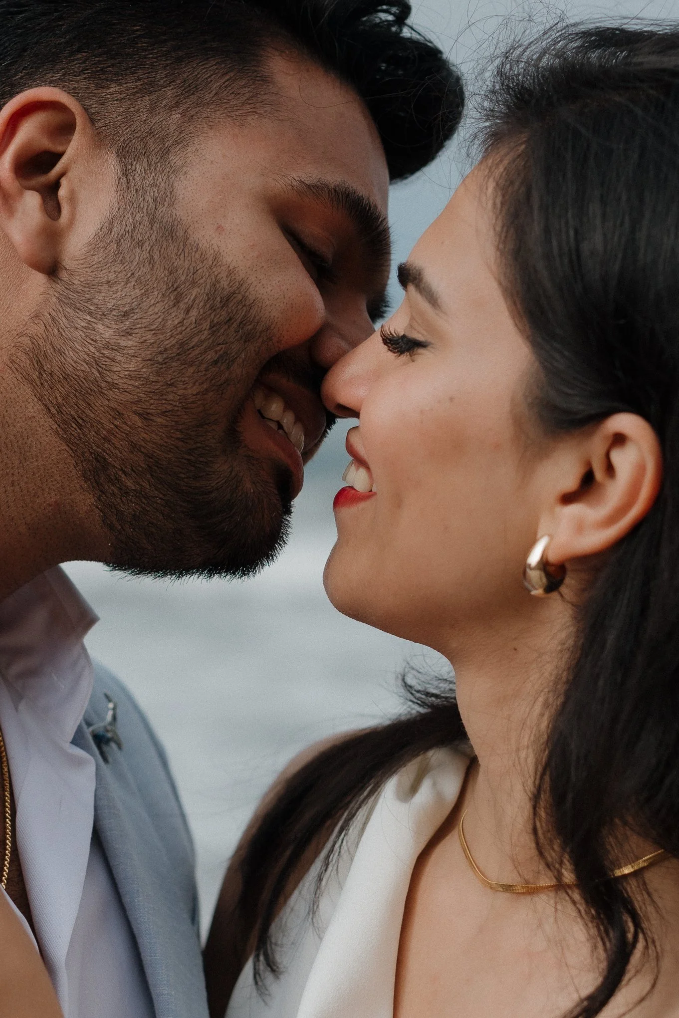 A close-up of a man and woman with their foreheads and noses touching, eyes closed, sharing an intimate moment.