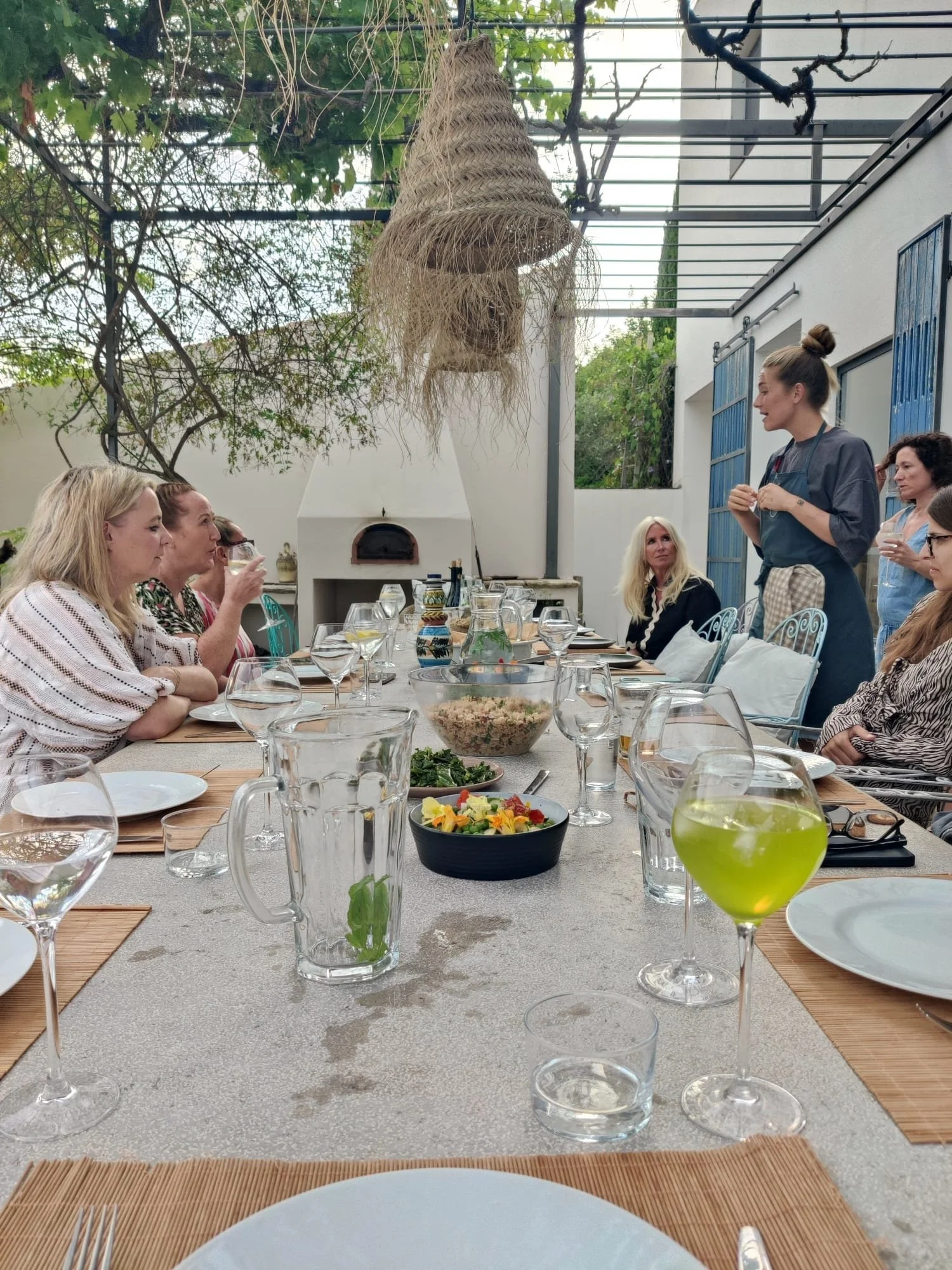 Retreat guests sharing a meal outdoors, representing connection, laughter and community.