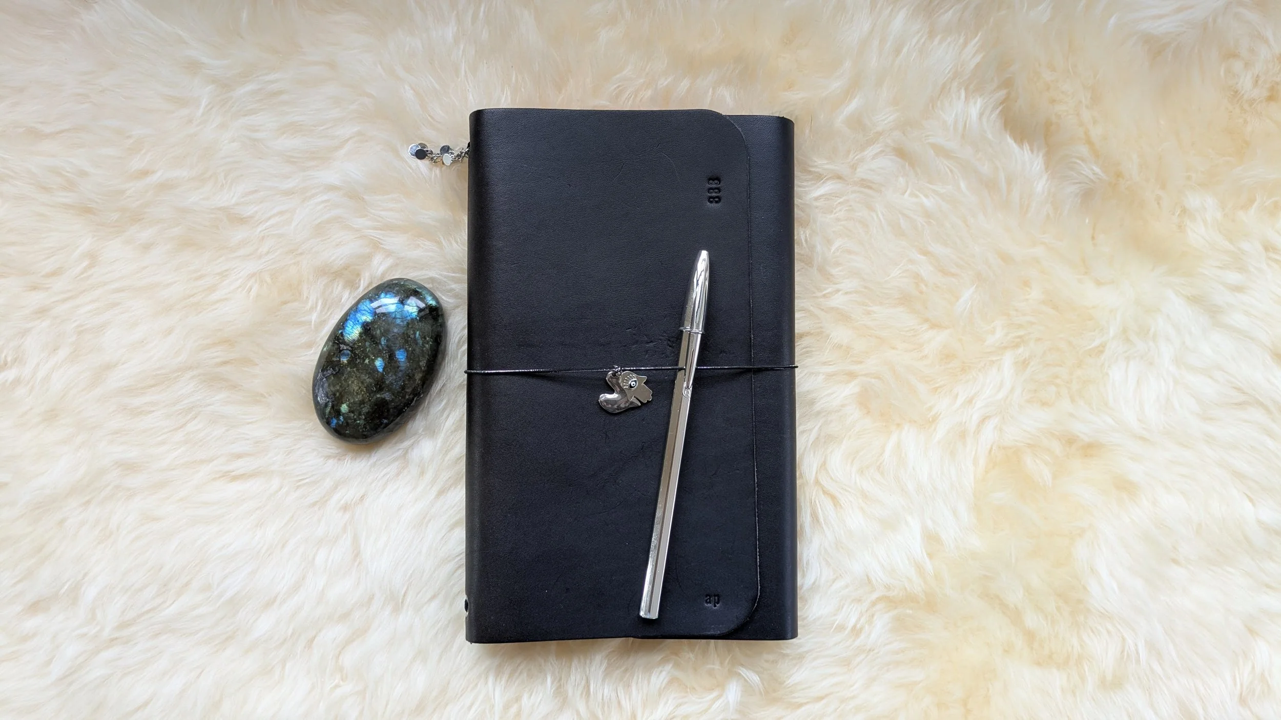 Inspirational journal, pen, hamsa, heart and labradorite on sheepskin.