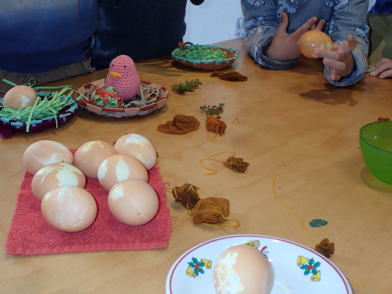 Osterdekoration mit Eiern, Sträuchern und kleinen Figuren.