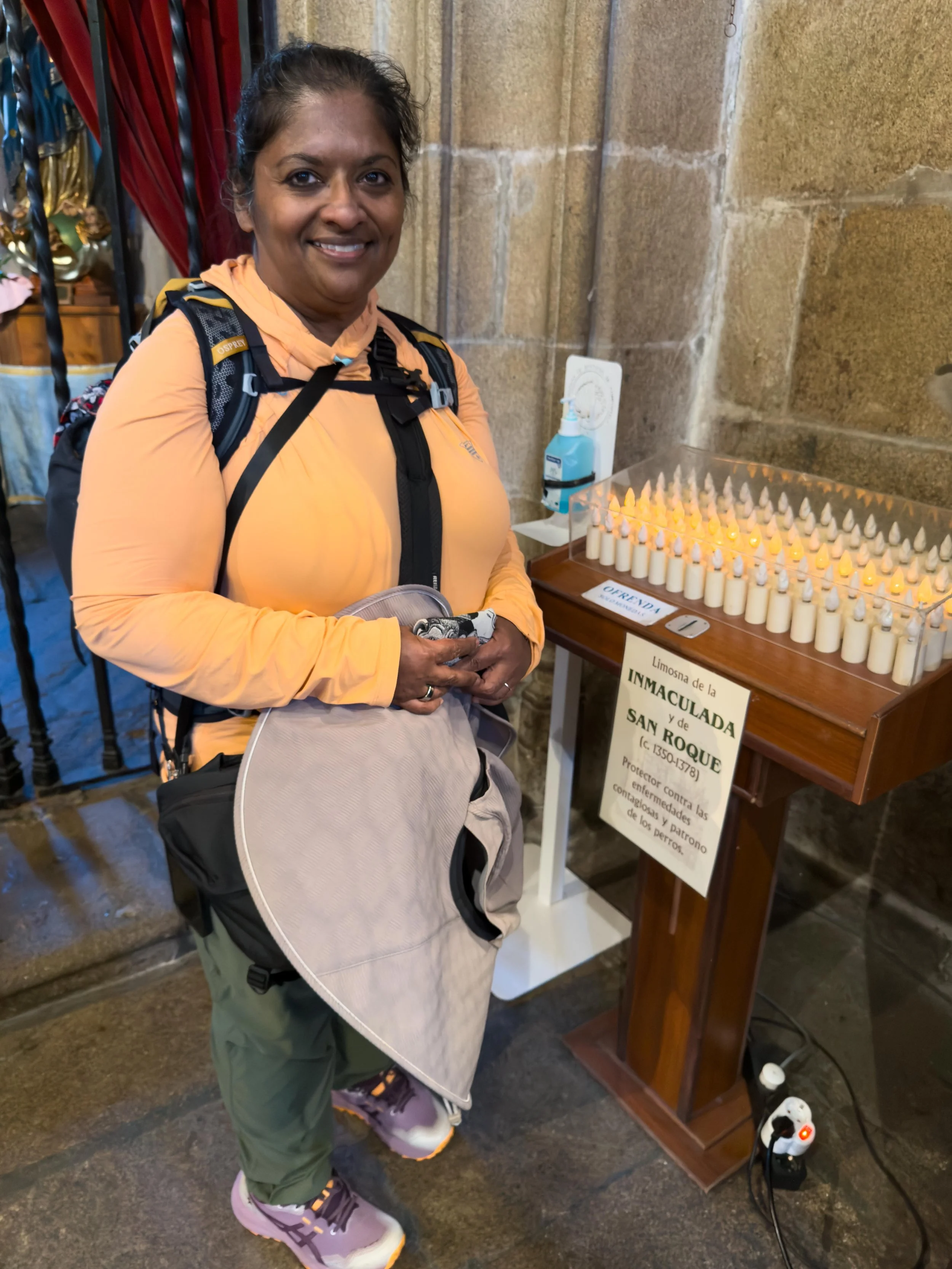 Sunita lighting a candle for San Roque, the patron saint of dogs.