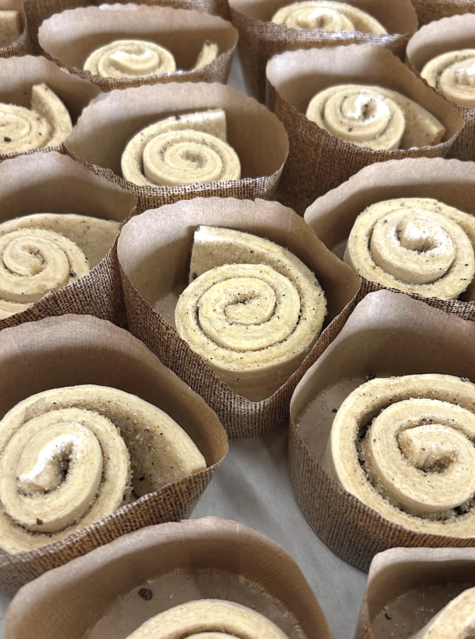 Close-up of uncooked cinnamon rolls in paper baking cups