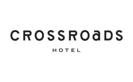 Logo of Crossroads Hotel with black text on a white background.