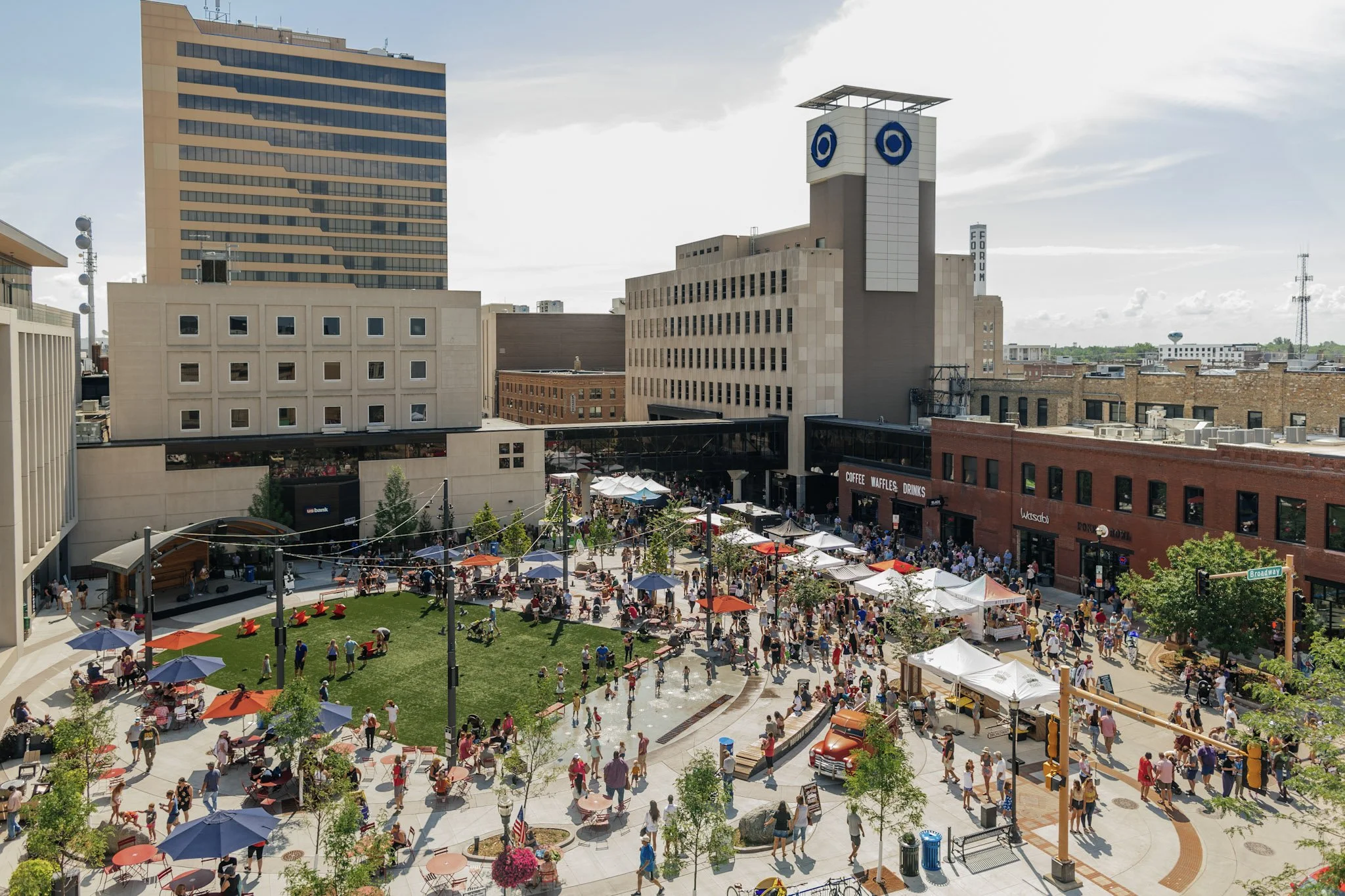 Market full of people walking around in Broadway Square