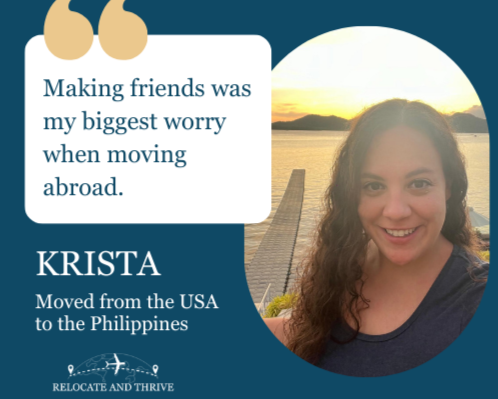 Modern wooden building with large glass window set against mountainous landscape with grassy foreground and cloudy sky.