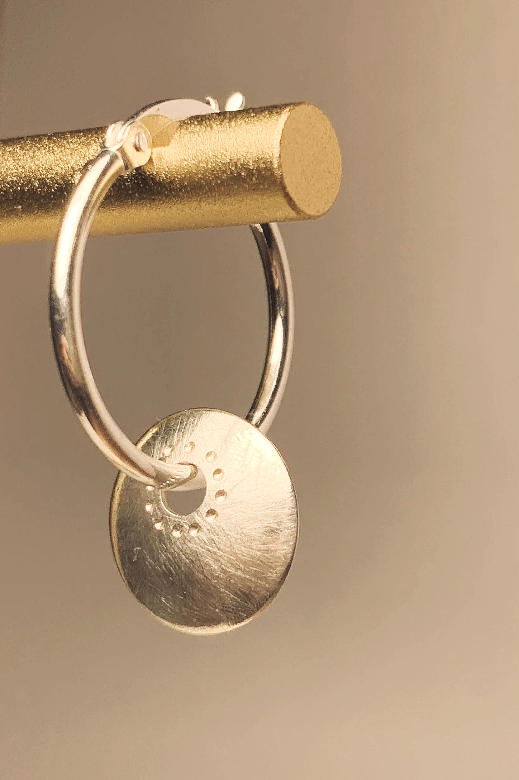 Close-up of a metallic keychain with two keys hanging from a metallic gold-colored rod.