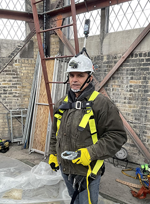 Chris Hartnett preparing to ascend for an inspection of a church steeple.