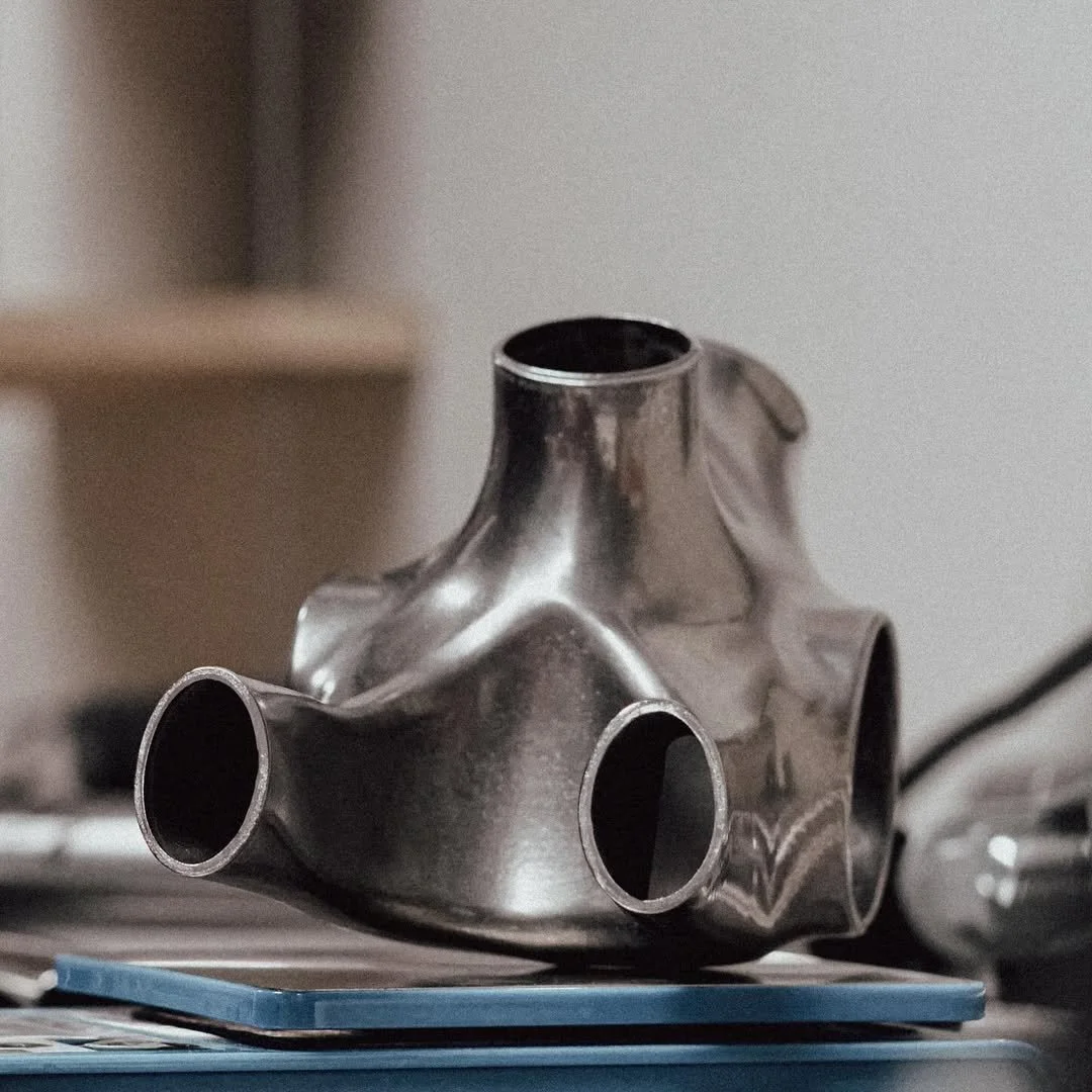 A metallic bicycle headset in a silver finish, resting on a table with a blue mat underneath.