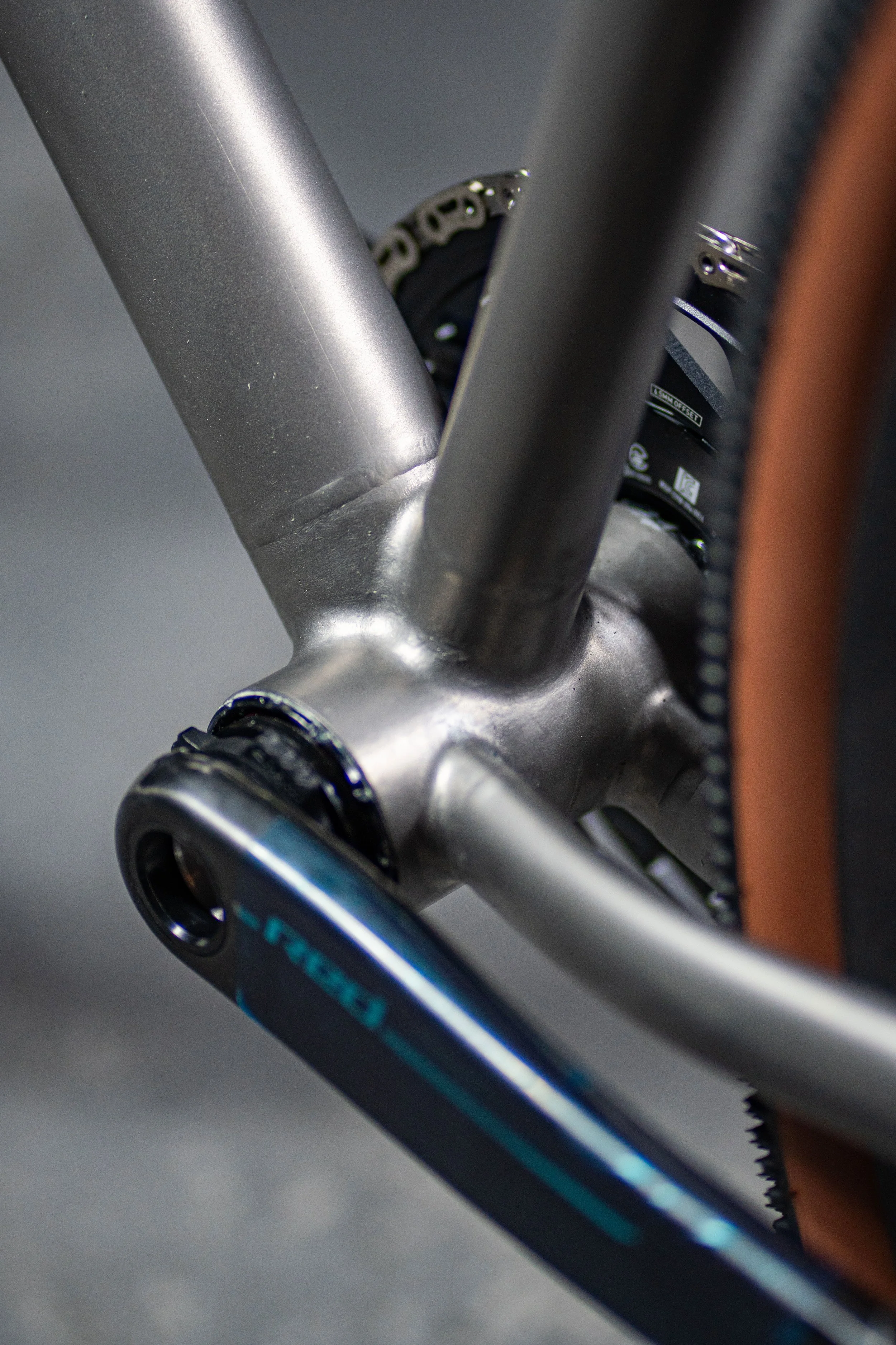 Close-up of a modern bicycle's crankset and bottom bracket area, including the chainring, crank arm, and part of the frame.