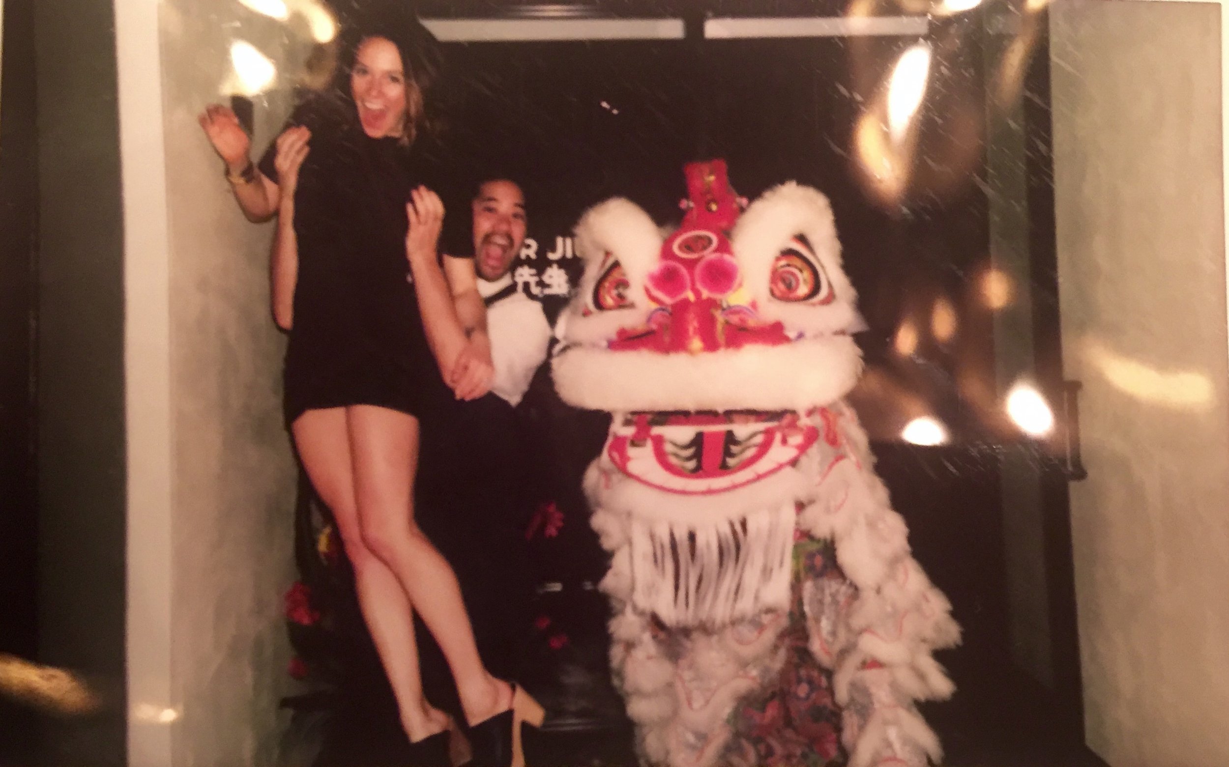 A man and woman smiling and posing with a traditional Chinese lion dance costume.