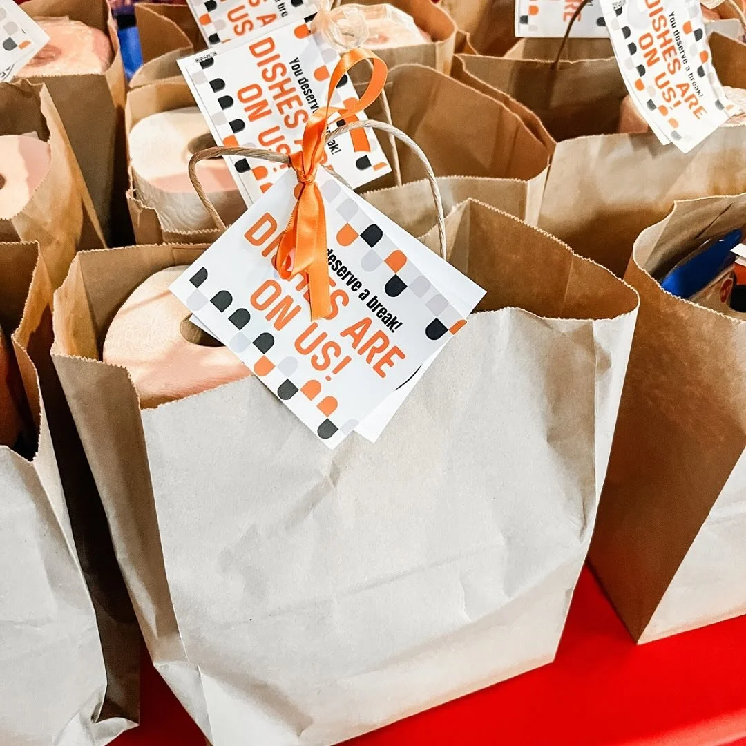 Bags of snacks for caregivers and a message to them, decorated with orange ribbon.