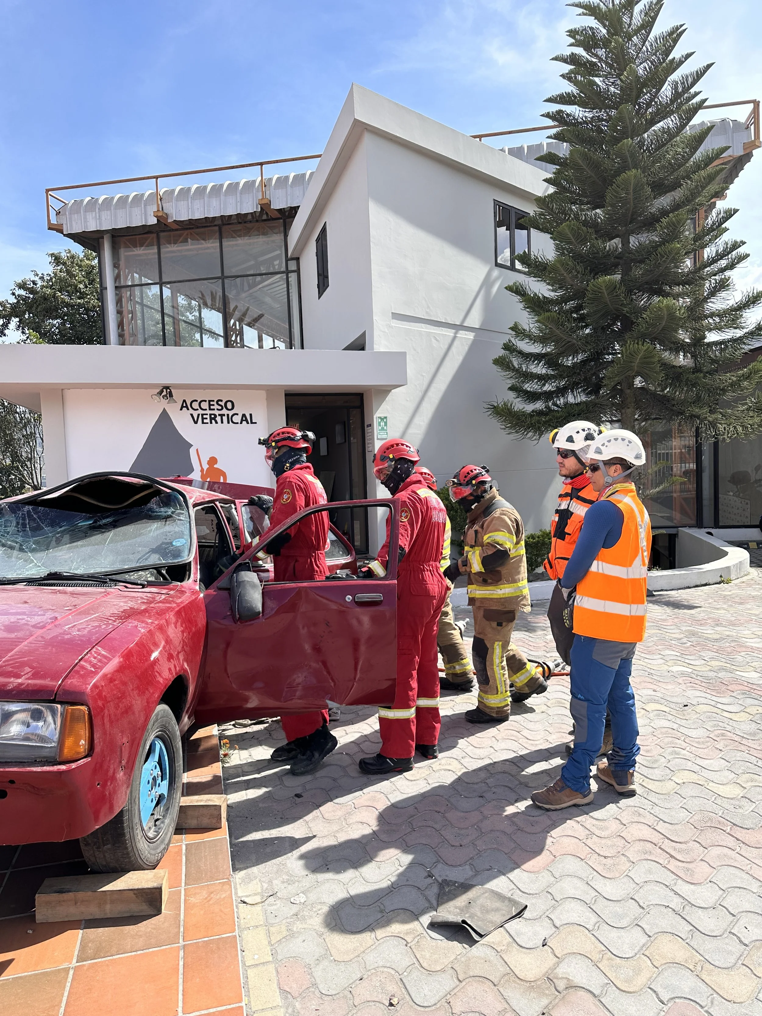 Rescate de personas en un automóvil accidentado con personal de emergencia y bomberos en el lugar.