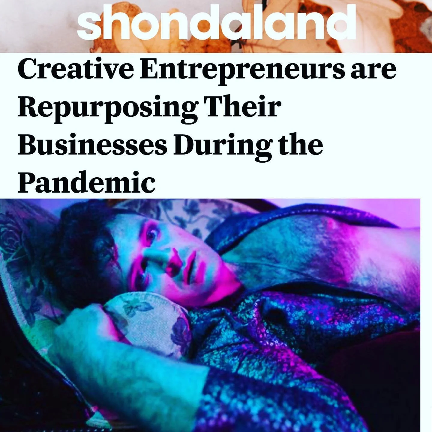 Natti Vogel lying on a bed under colorful lighting, with his head resting on a pillow and looking towards the camera. Screenshot from Shondaland article part 1