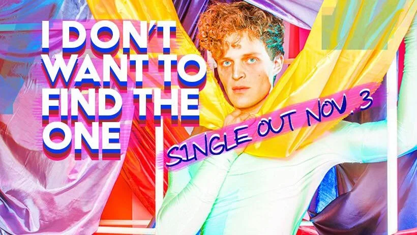 Colorful promotional poster for a single release featuring Natti Vogel with curly hair surrounded by multicolored shiny fabric, with bold text stating "I DON'T WANT TO FIND THE ONE," and handwritten text "Single Out Now 3."